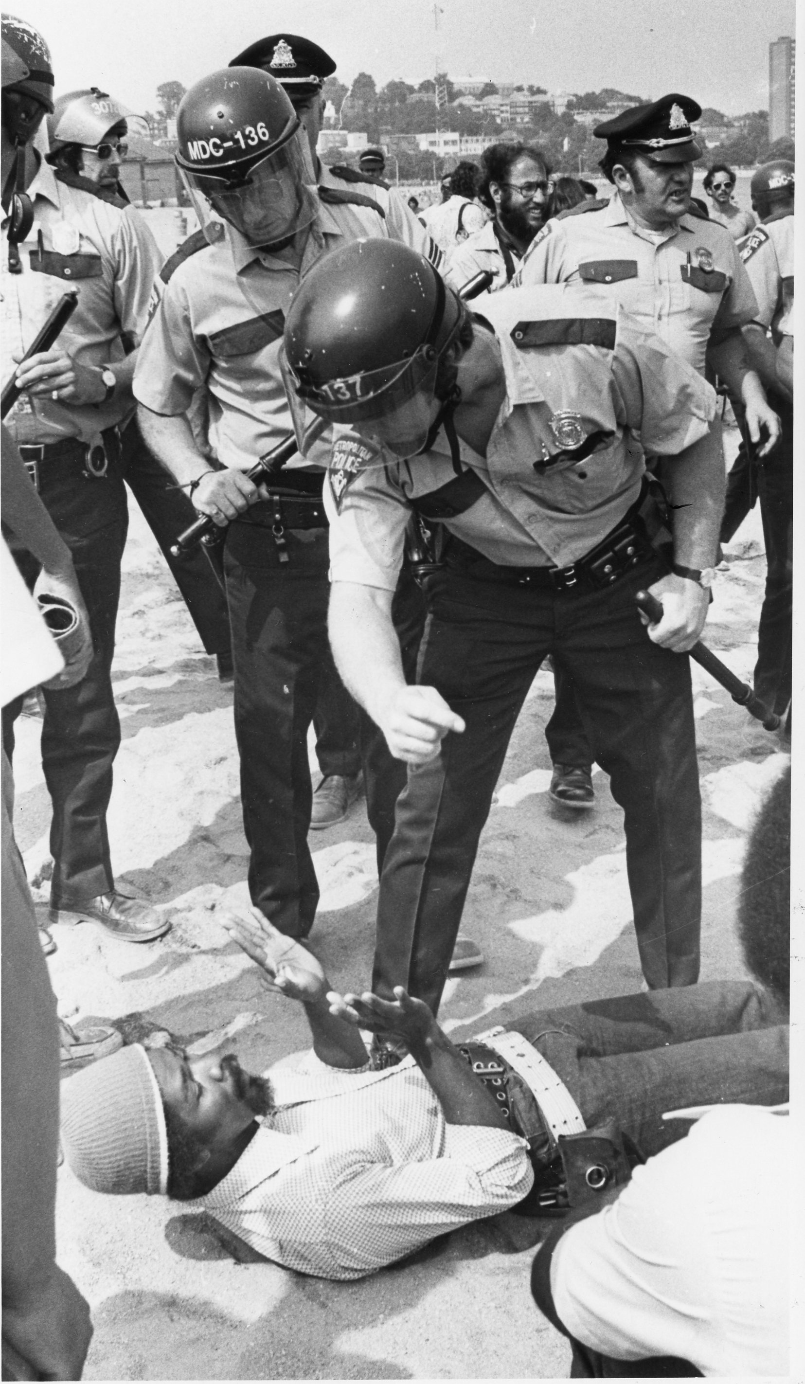 A police officer looms over a protester.