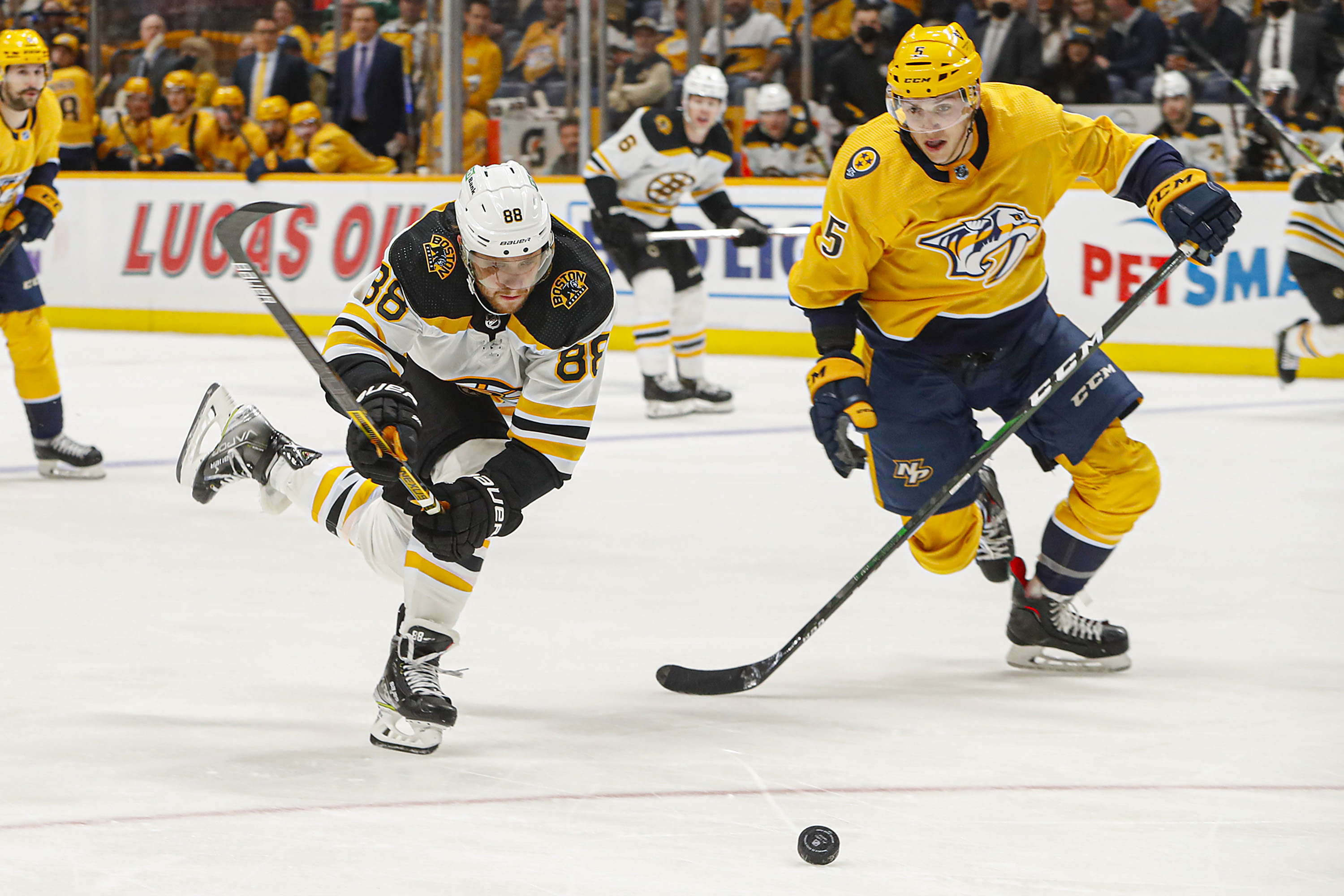 David Pastrnak and Nashville's Matt Benning chase the puck during the second period of Thursday's game.