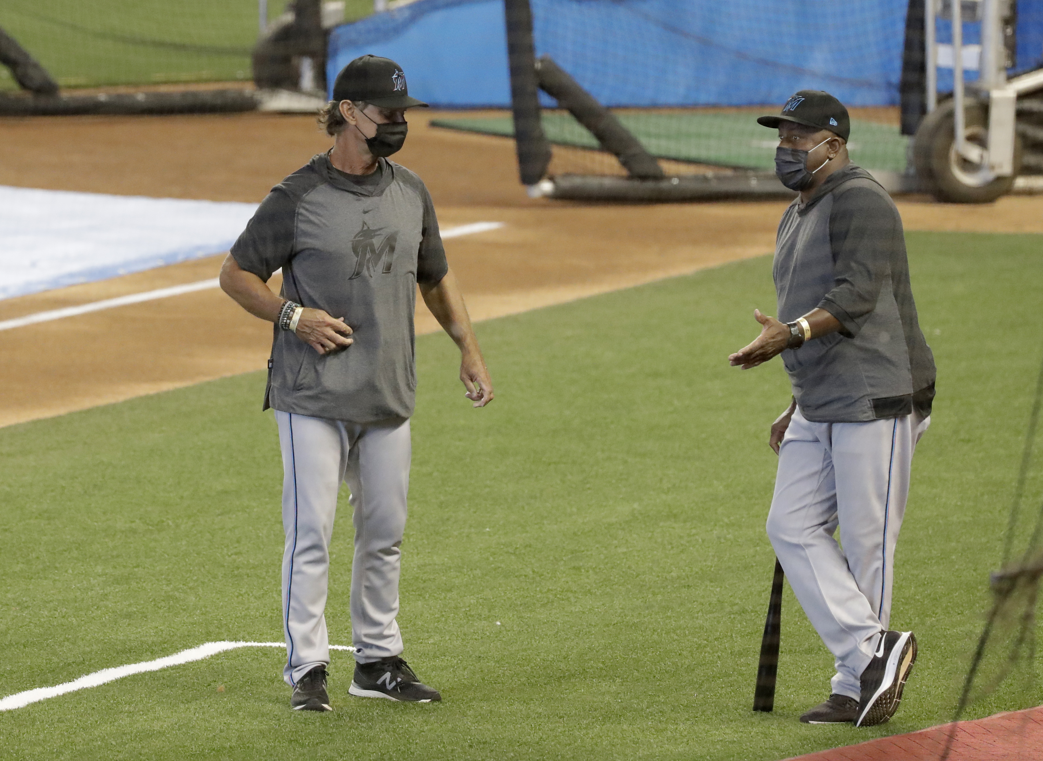 Marlins manager Don Mattingly, left, chats with bench coach James Rowson during a workout this past July.