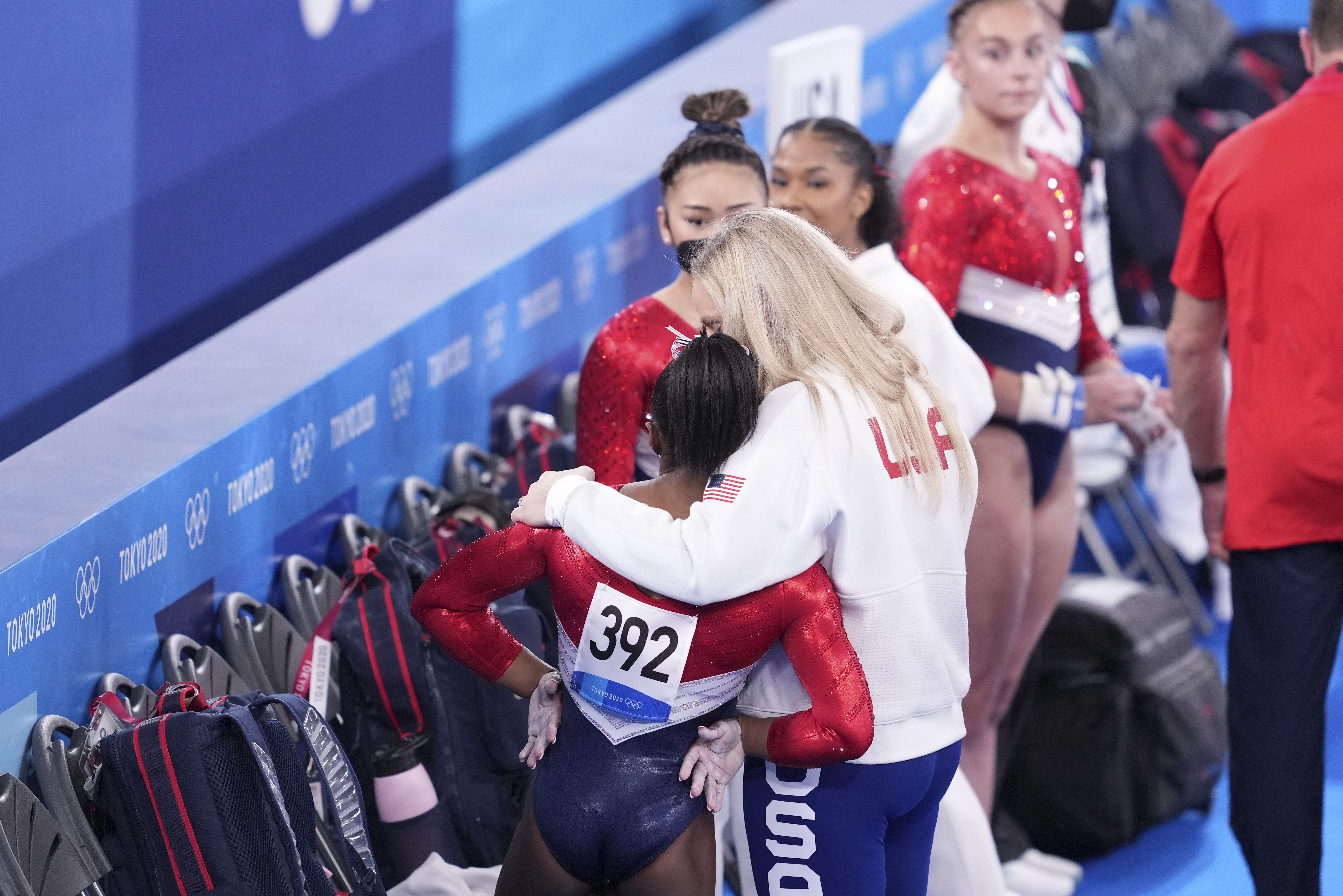 A coach hugs Simone Biles during the women's team gymnastics final, during the Tokyo 2020 Olympics on July 27.