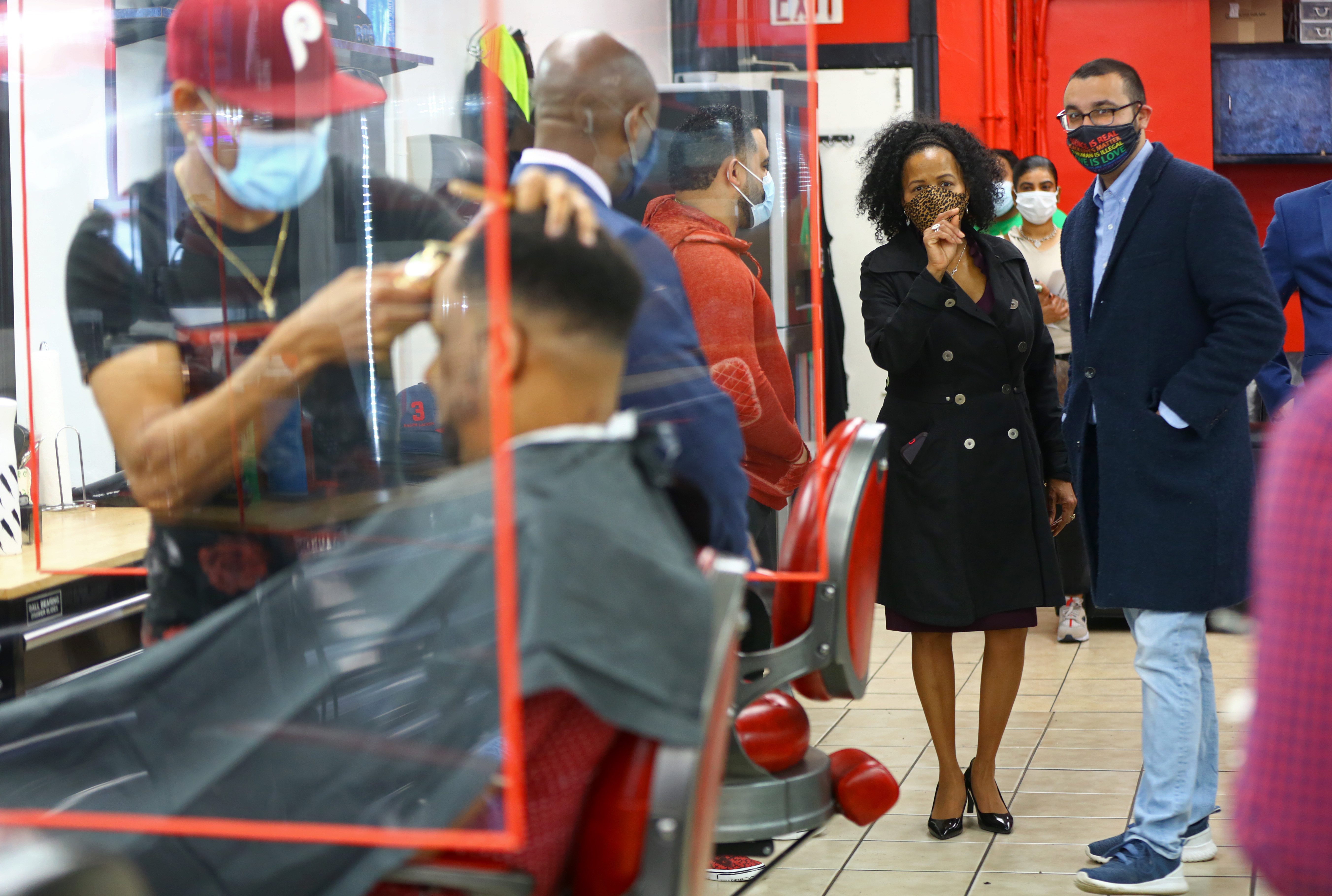 During her visit to Roslindale Barbershop, Acting Mayor Kim Janey chatted with owner Anderson Diaz (in red) and City Councilor Ricardo Arroyo, on May 10, 2021.