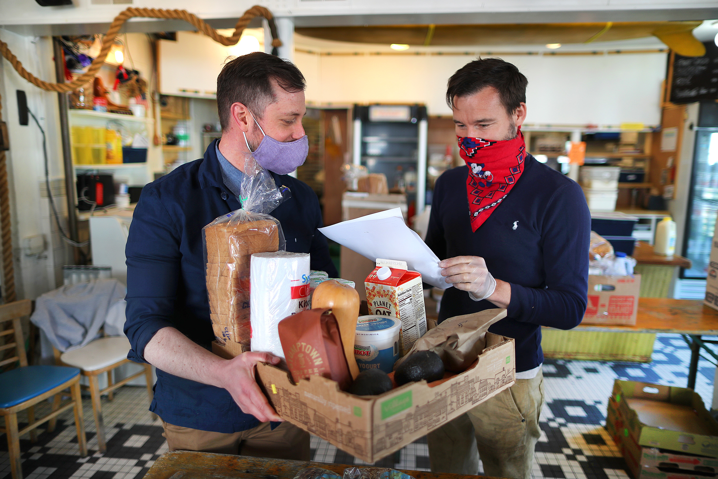 Rob Anderson (left), co-owner of Canteen on Commercial Street, and his partner Loic Rossignon made up a grocery order for delivery.
