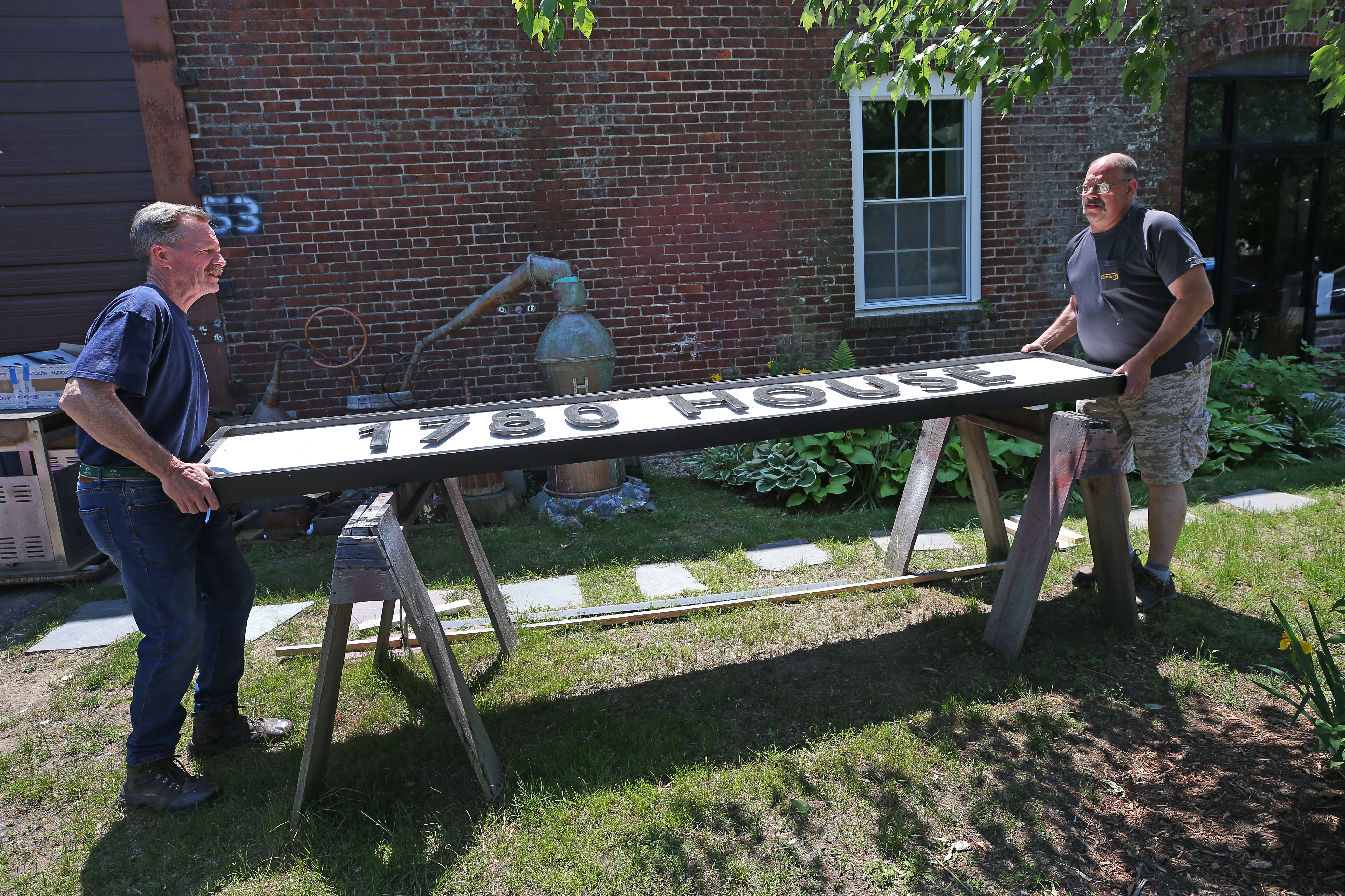 Billy Crosby (left) moves an almost finished sign for a customer with his helper Jack Wheeler.