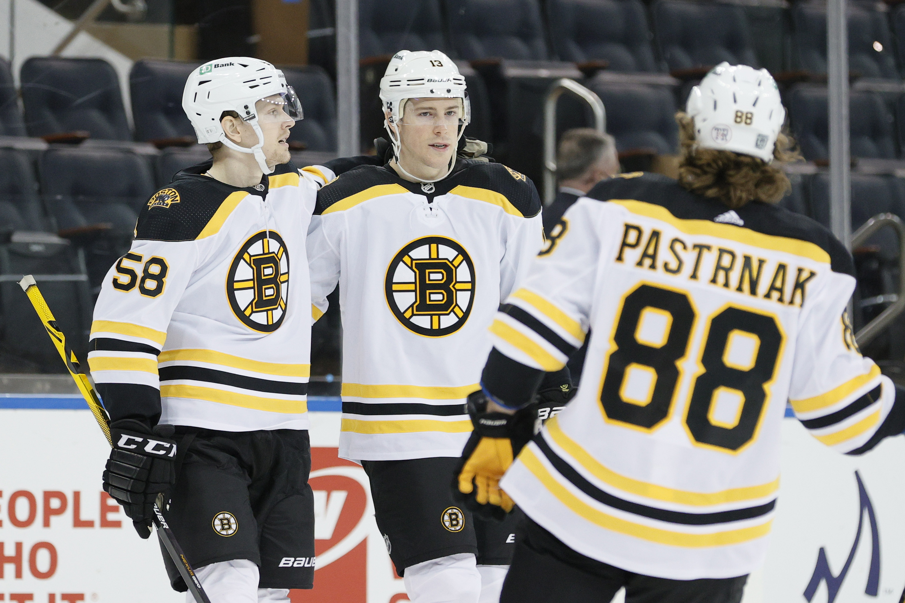 Charlie Coyle (center) celebrates his first of two goals Sunday with Bruins teammates David Pastrnak (88) and Urho Vaakanainen.