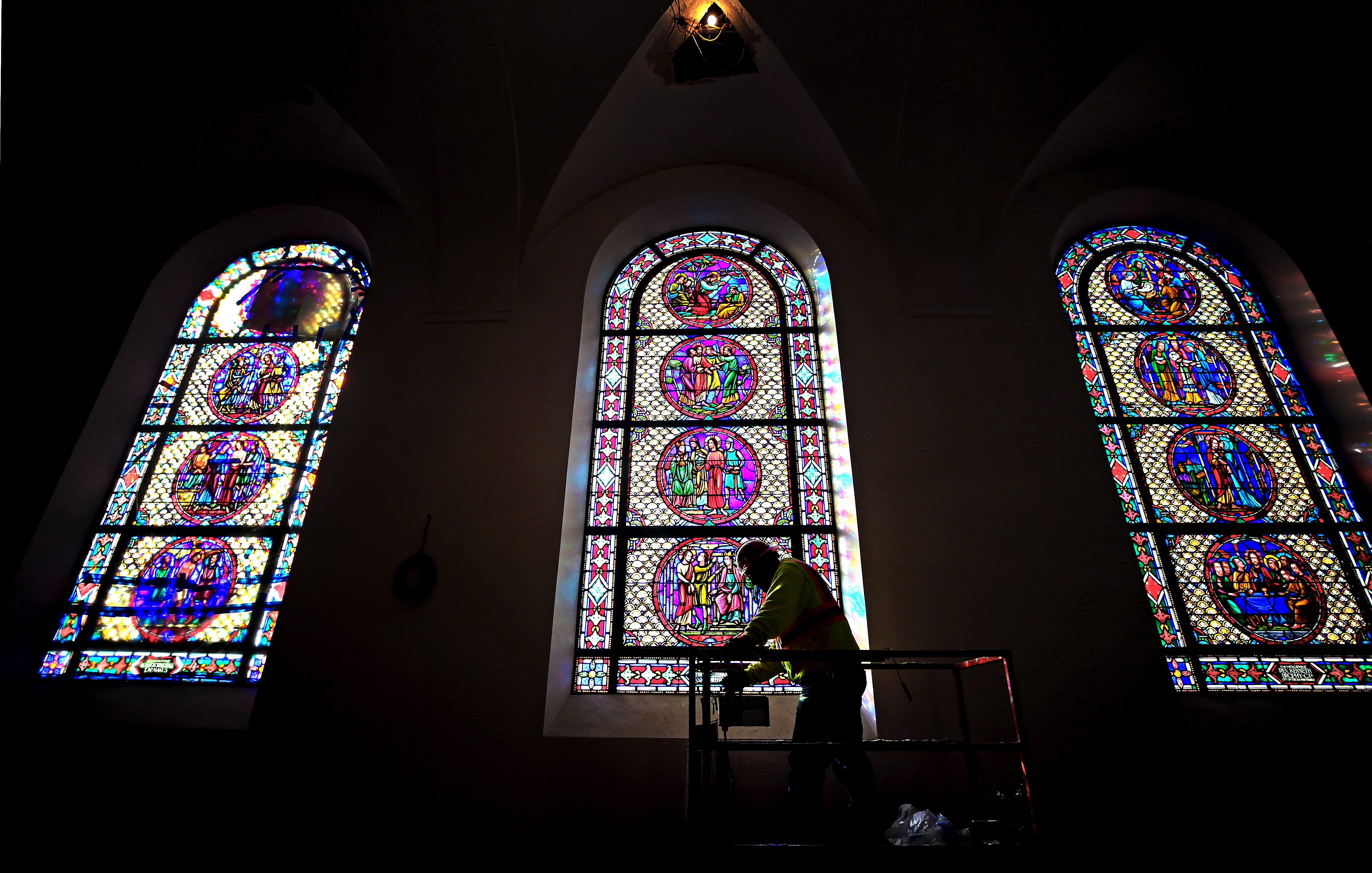 Construction worker Mohmed El Bhawan on a lift passed restored stained glass windows inside St. Gabriel’s Church during restoration work on January 22.