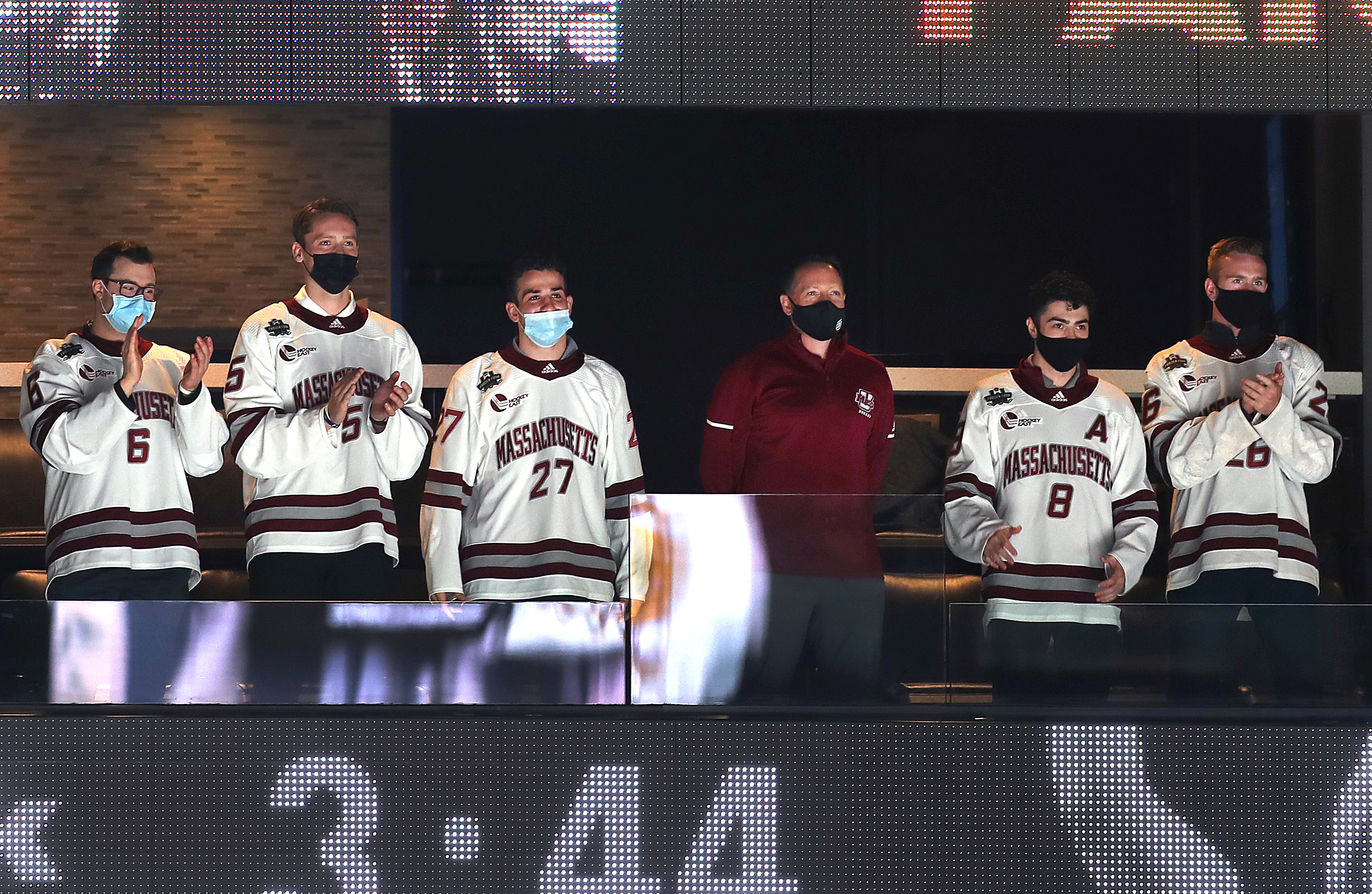 The national champion UMass Minutemen hockey team, including head coach Greg Carvel (center), was honored at Saturday's game.