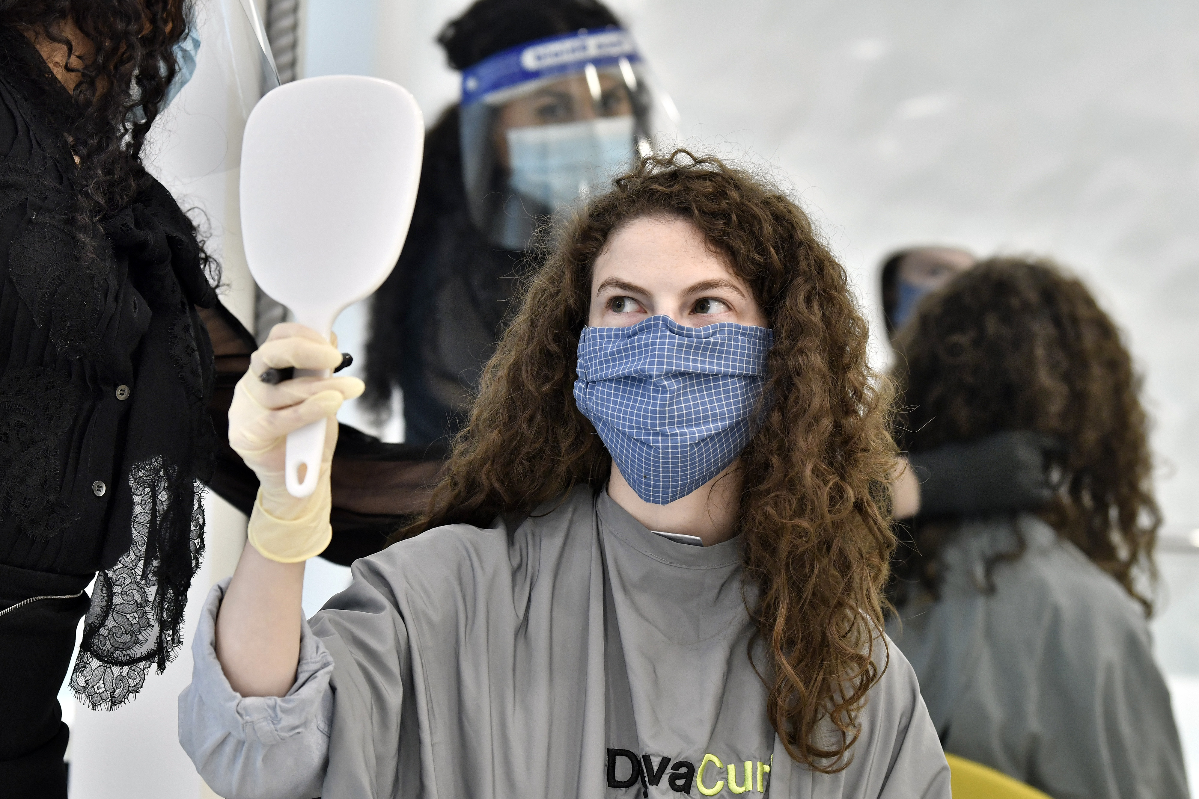 Salon owner Teo Sorce wore a face shield and mask in order to meet state guidelines.