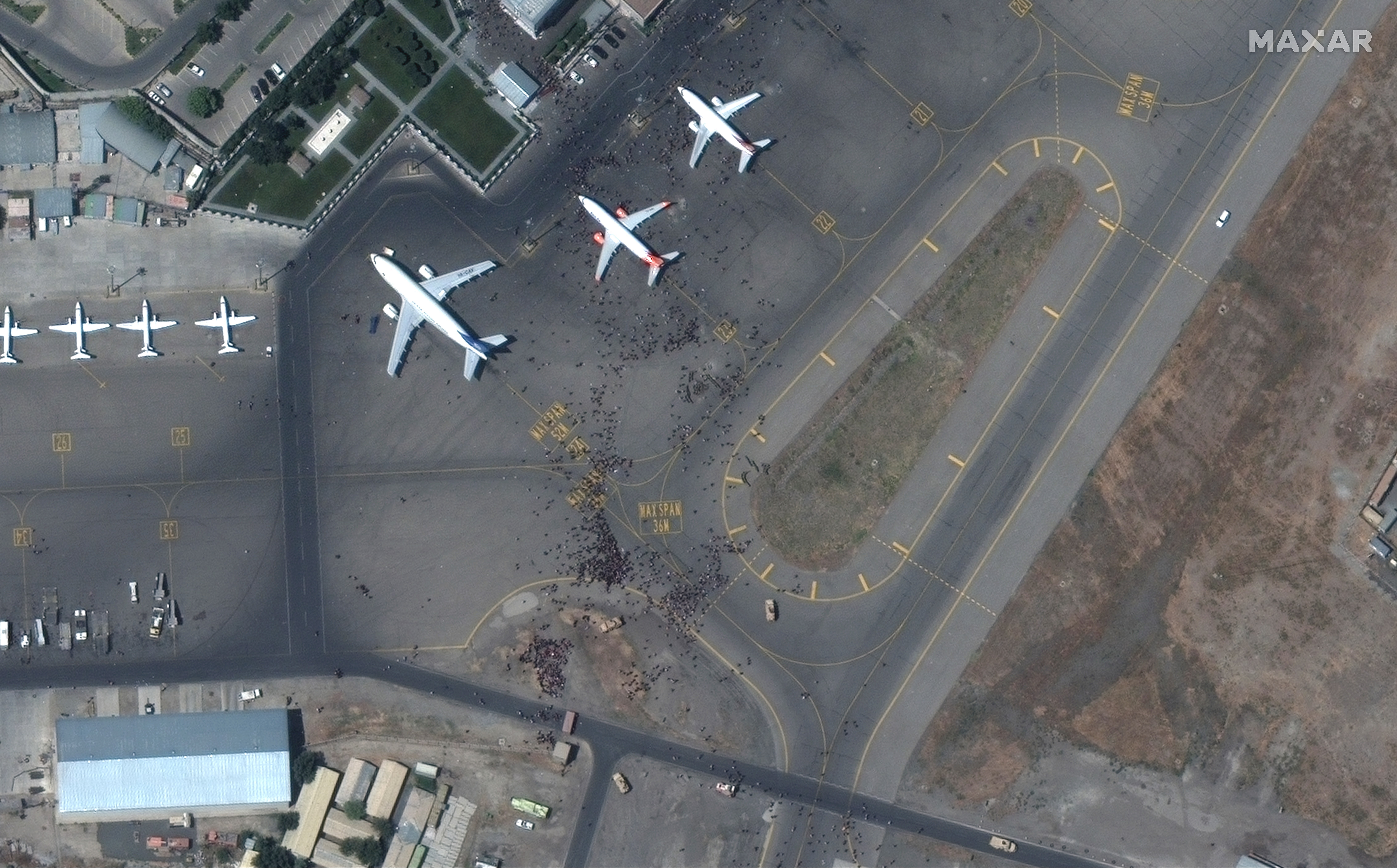 A satellite photo provided by Maxar Technologies shows people on the tarmac at Kabul’s international airport.