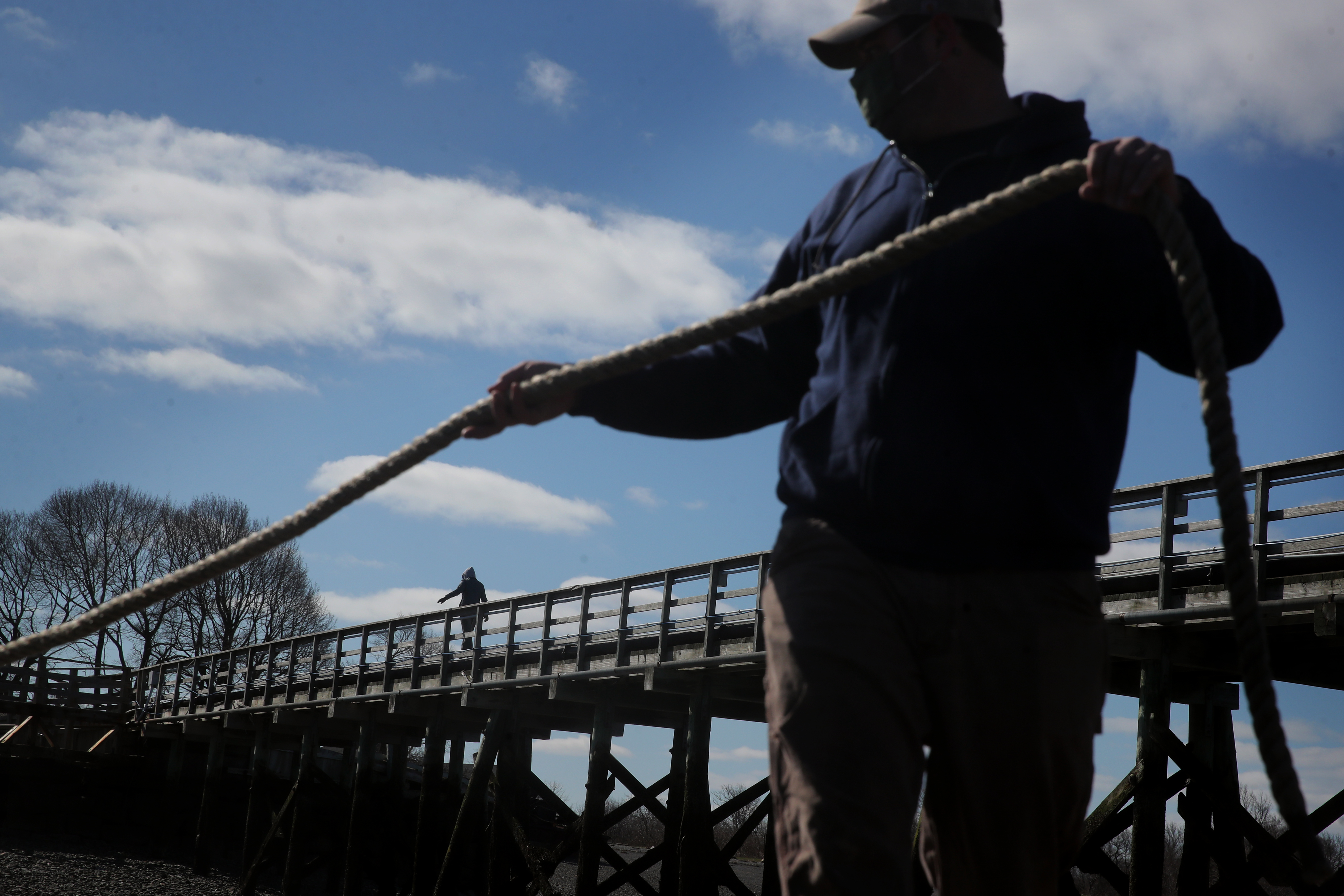 Wills walked on the dock as Captain Alec Heilmann (right) departed Thompson Island in Boston Harbor.