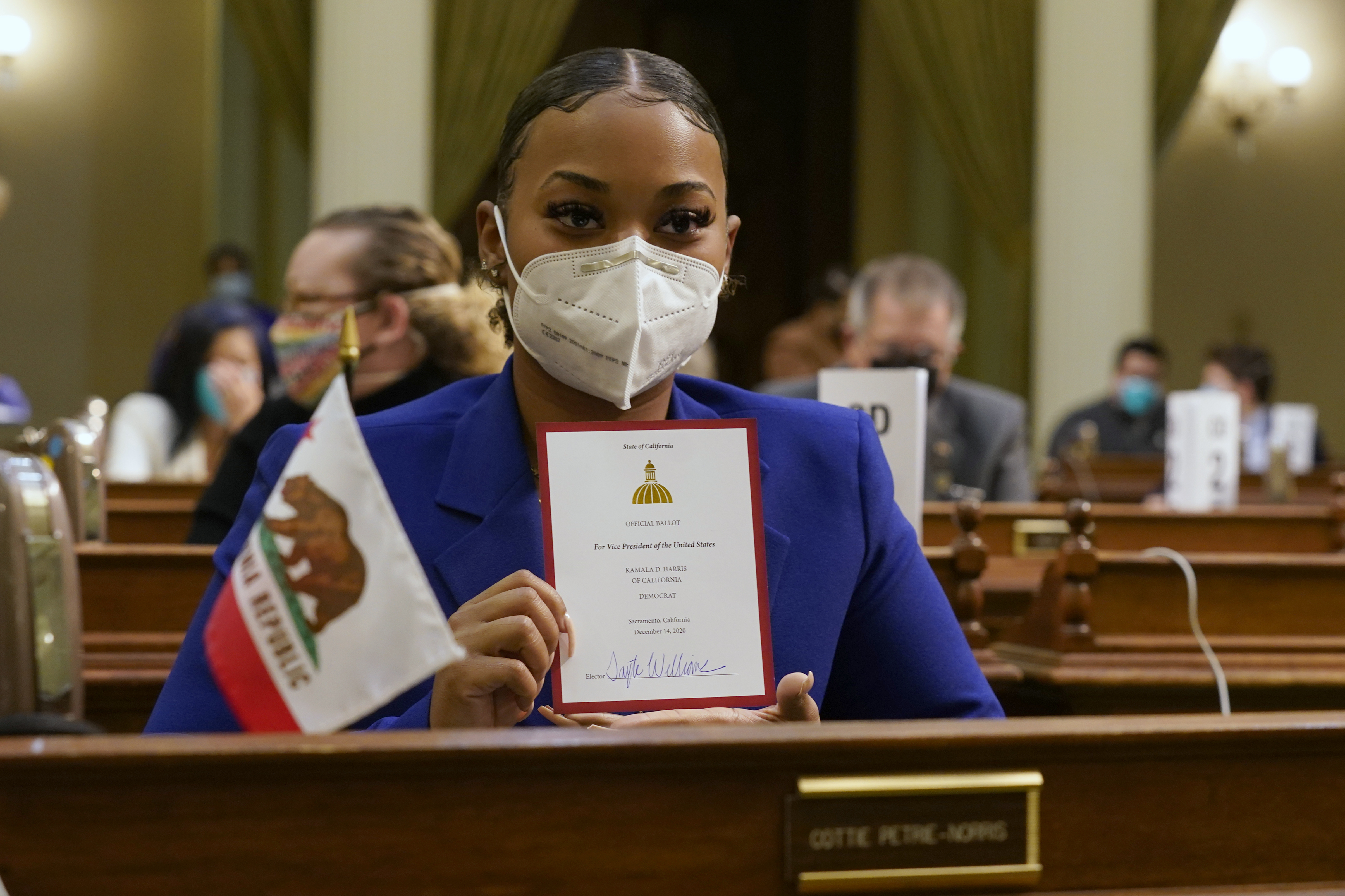 Tayte Williams a member of California's Electoral College holds up her ballot for Vice President-Elect, Sen. Kamala Harris at the state Capitol in Sacramento, Calif., on Monday.