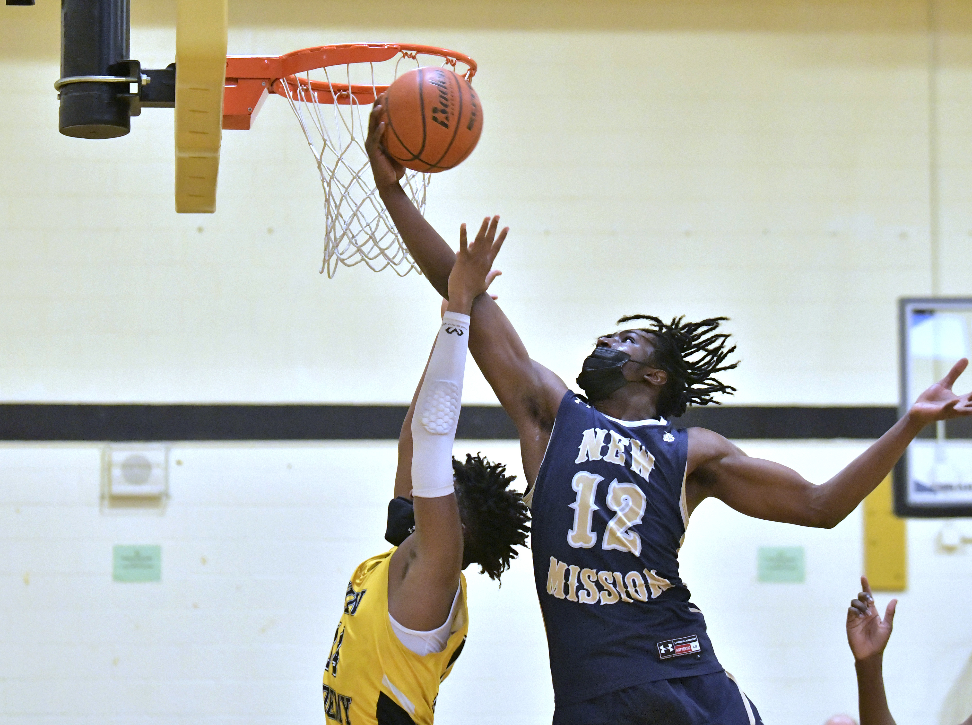 New Mission's Kemar Morgan (12) rips a rebound away from Latin Academy's Mason Lawson.