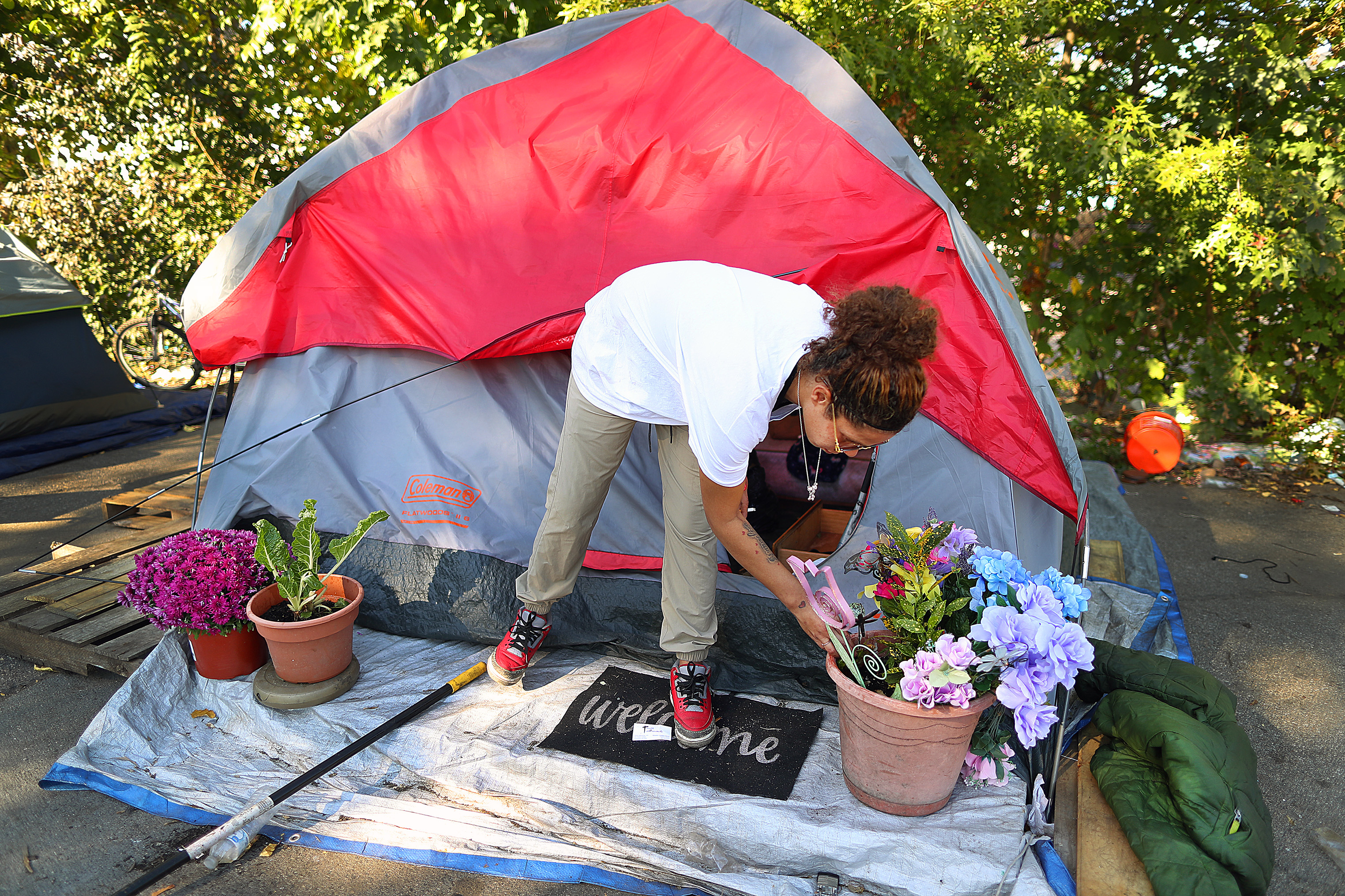 Carmen Vargas took a moment to water her treasured plants in front of the tent where she and her boyfriend, Harlen Perez, have lived in for 8 months. ”I don’t want to leave here. This is my home,” Vargas said of the encampment on Fuller Street in Providence that she has been ordered to leave.