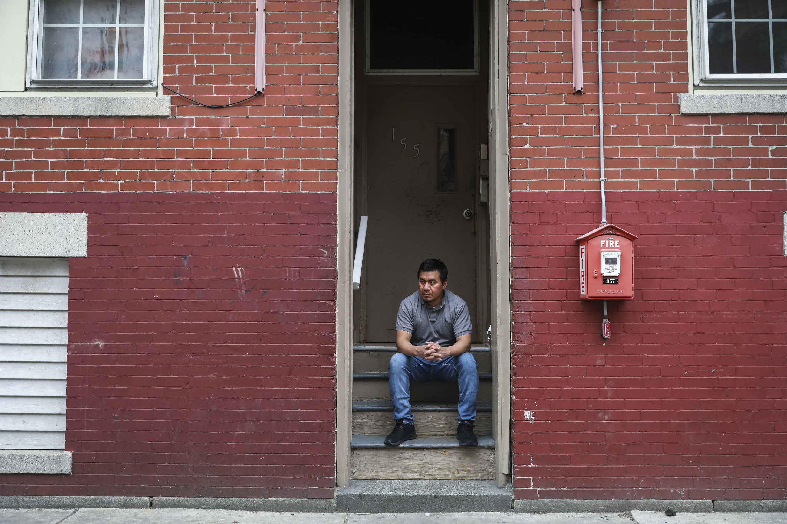 Fredy Sanan sat on the steps leading up to his apartment.