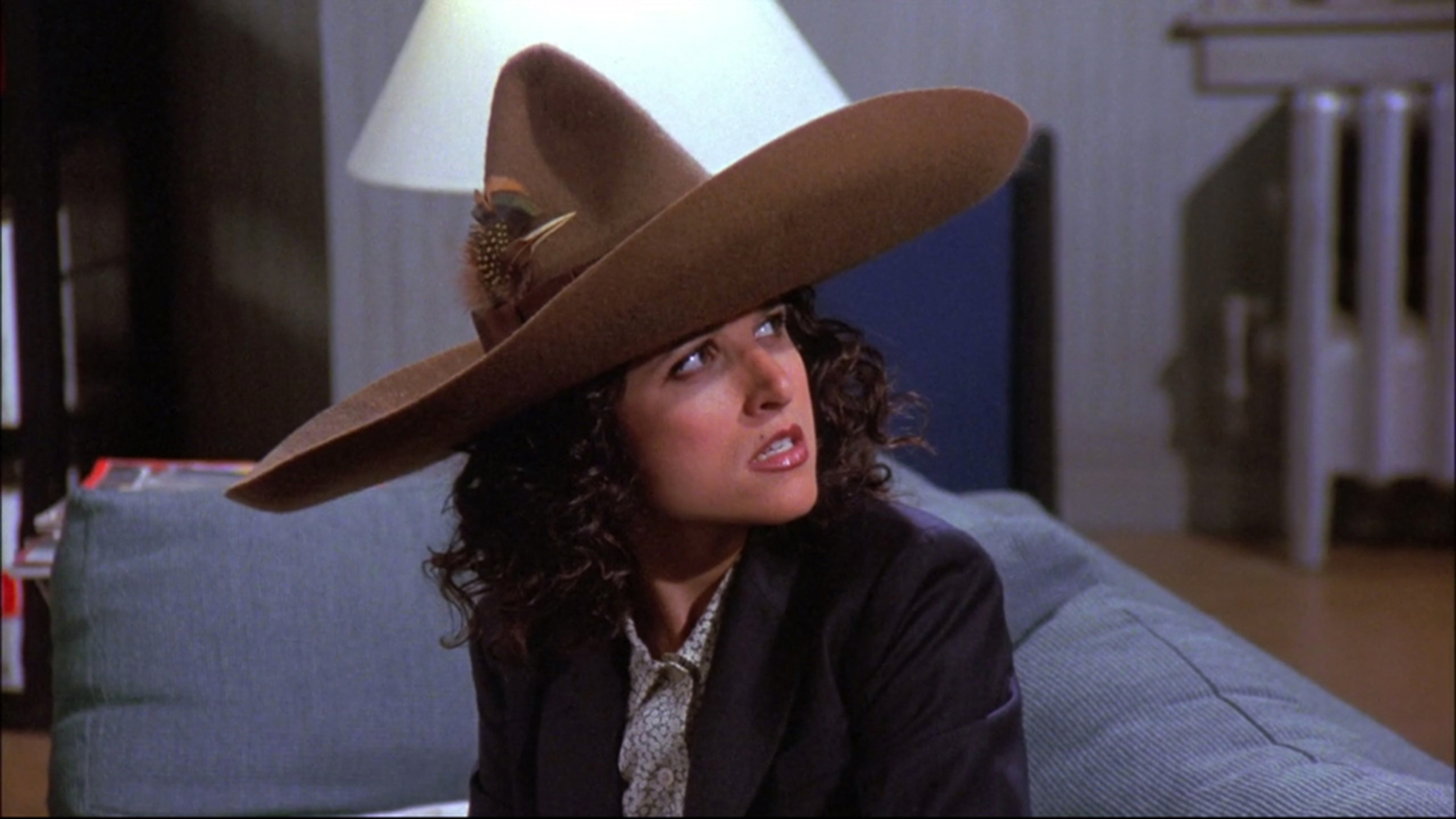 Julia Louis-Dreyfus as Elaine Benes wearing the J. Peterman "urban sombrero" on an episode of Seinfeld.
