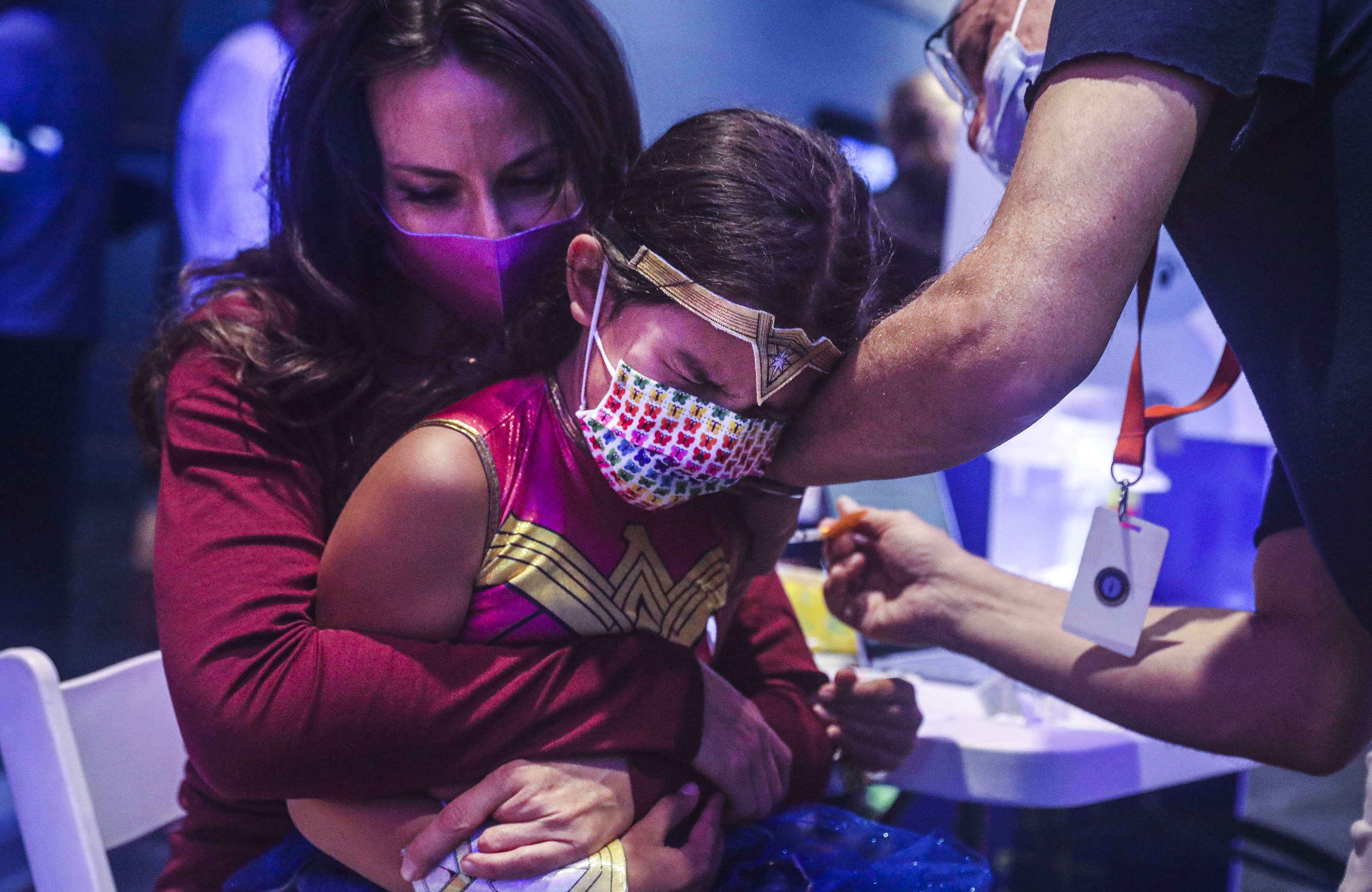 dr.  Elizabeth Taglauer held her 7-year-old daughter Alanna Khan, who was dressed as a superwoman, while she received her COVID-19 vaccine.