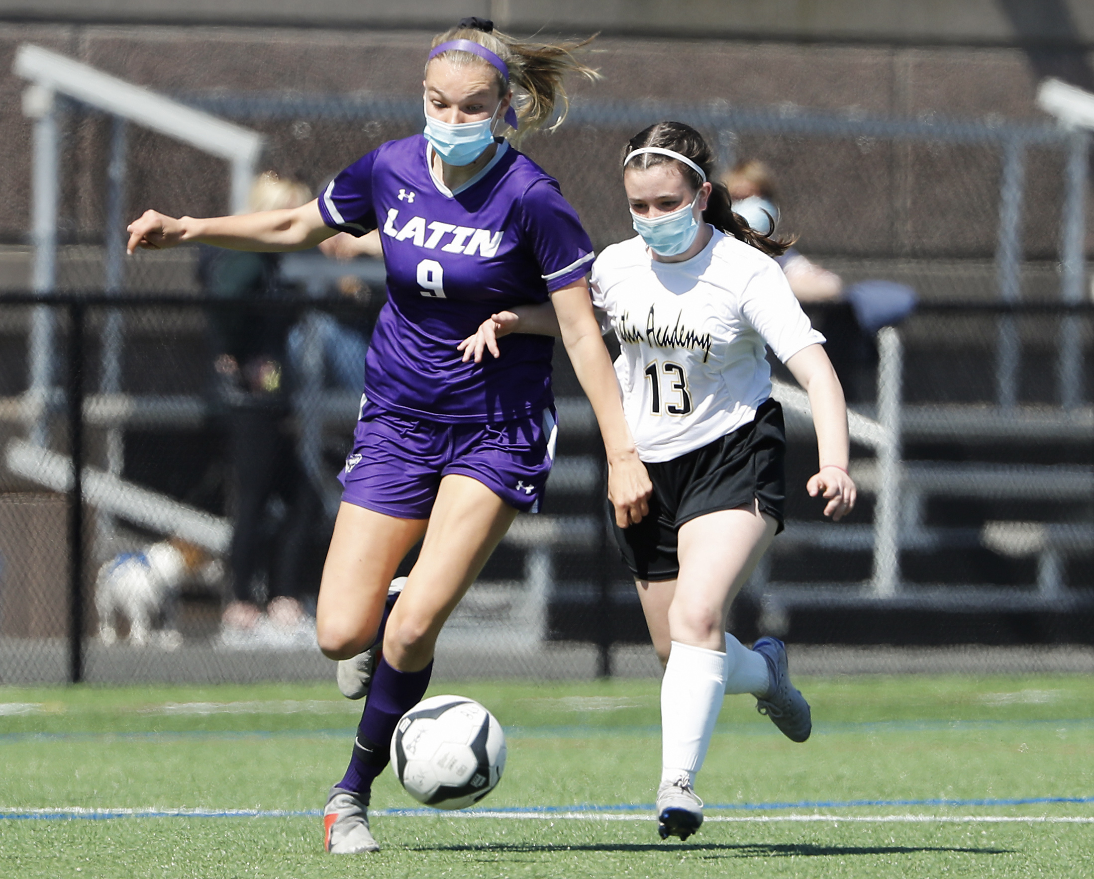 Boston Latin's Quinlan O'Brien controls the ball while being chased by Latin Academy's Lucy Robidoux.