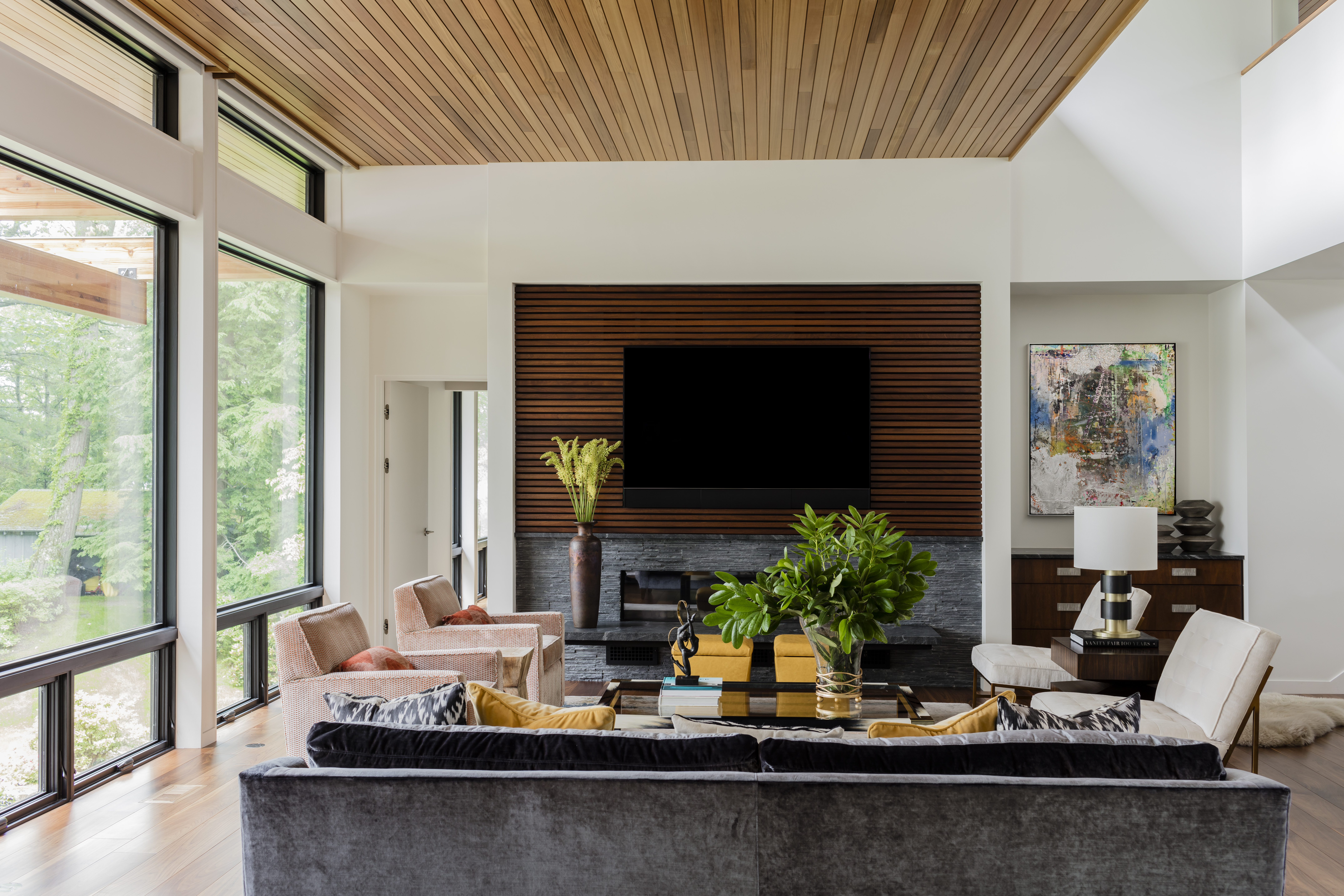 Custom upholstered Mitchell Gold + Bob Williams swivel chairs provide a punch of subtle color beside the steel blue sofa, which determined the palette. The dynamic abstract painting by Bernd Haussmann ties everything together.