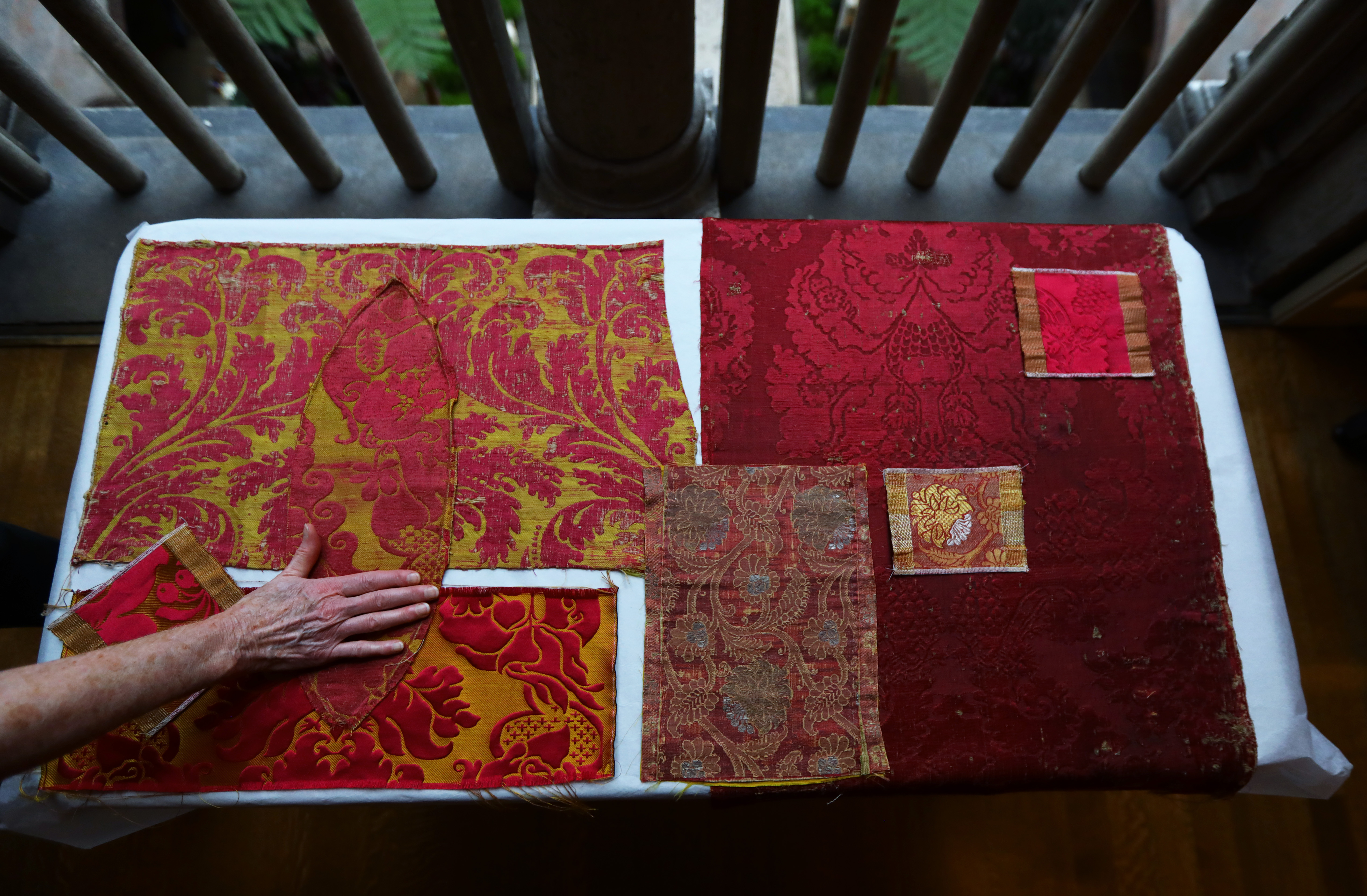 Senior textile conservator Tess Fredette displays historic reproductions of silk wall fabrics. The historic pieces are the pointed oval and large rectangle on the left and the smaller and large rectangle on the right. During the renovation of the Titian Room in the Isabella Stewart Gardner Museum, particular attention has been given to the fabrics.