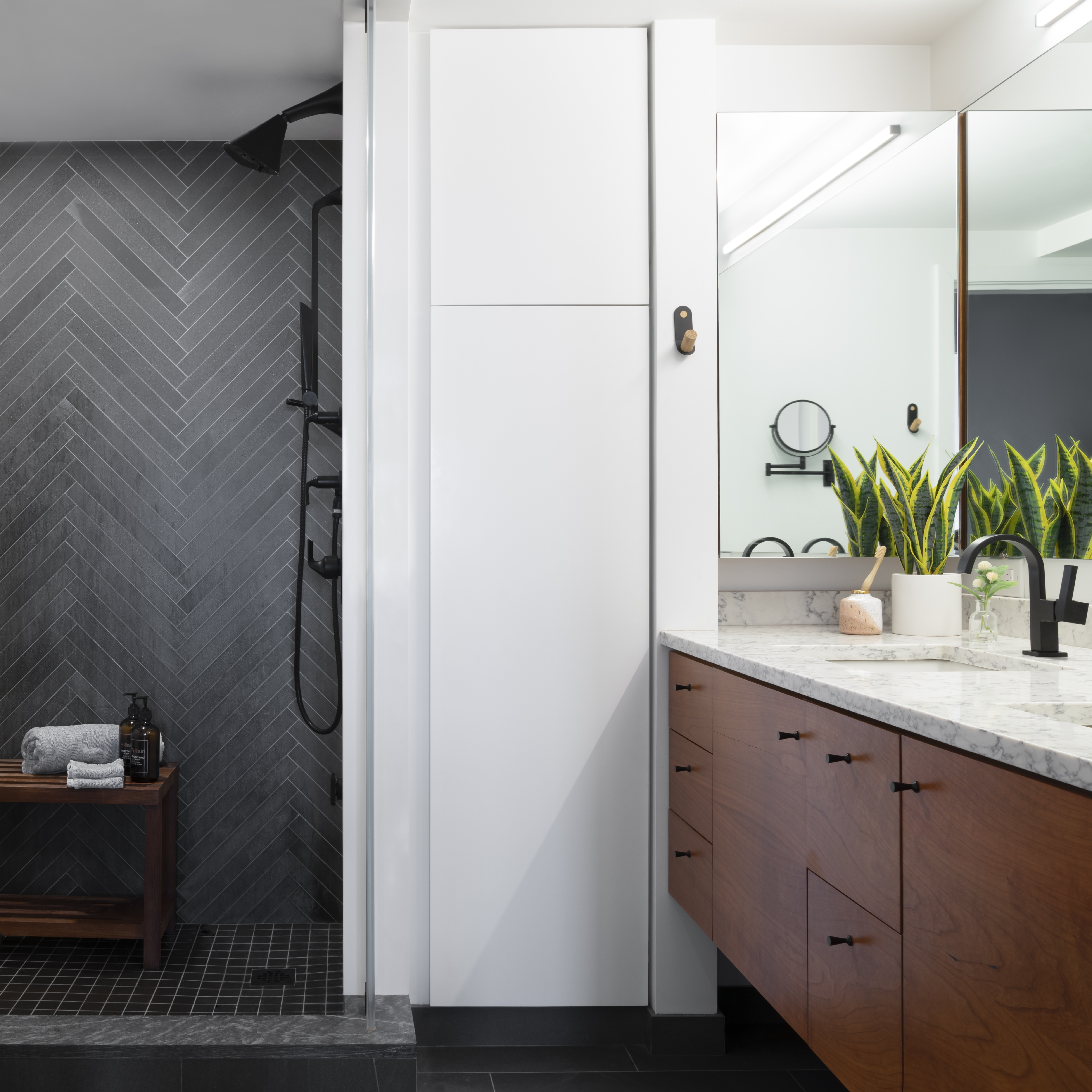 Marilyn Moedinger used dark materials for inset spaces, like the shower in the primary bath, which is lined in elongated limestone tiles.