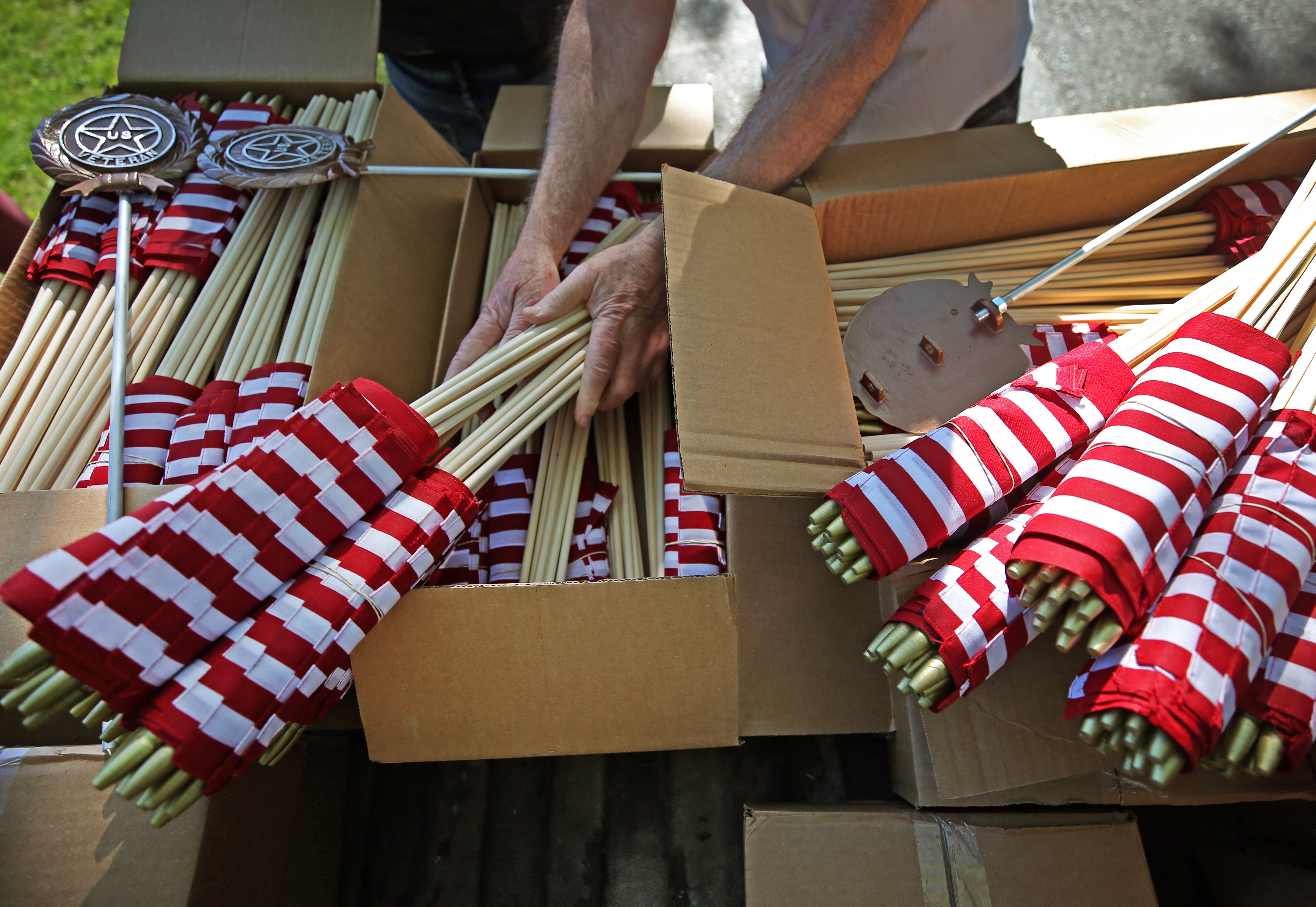 Joe Capone, a Worcester County reserve sheriff, sorts American Flags on the back of a pickup truck bed.