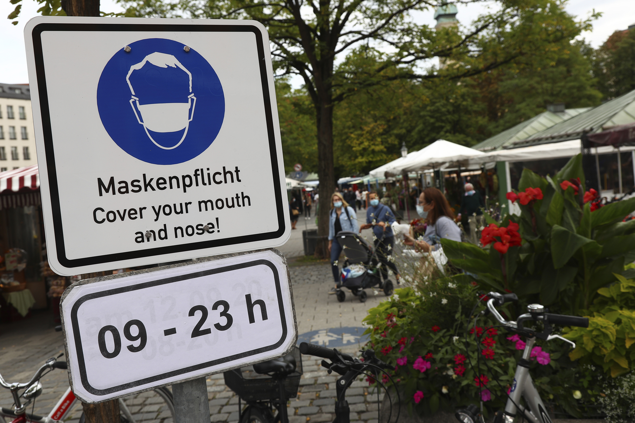 A sign that asks to wear face mask displayed at the 'Viktualienmarkt' in Munich, Germany, Thursday, Sept. 24, 2020. (AP Photo/Matthias Schrader)