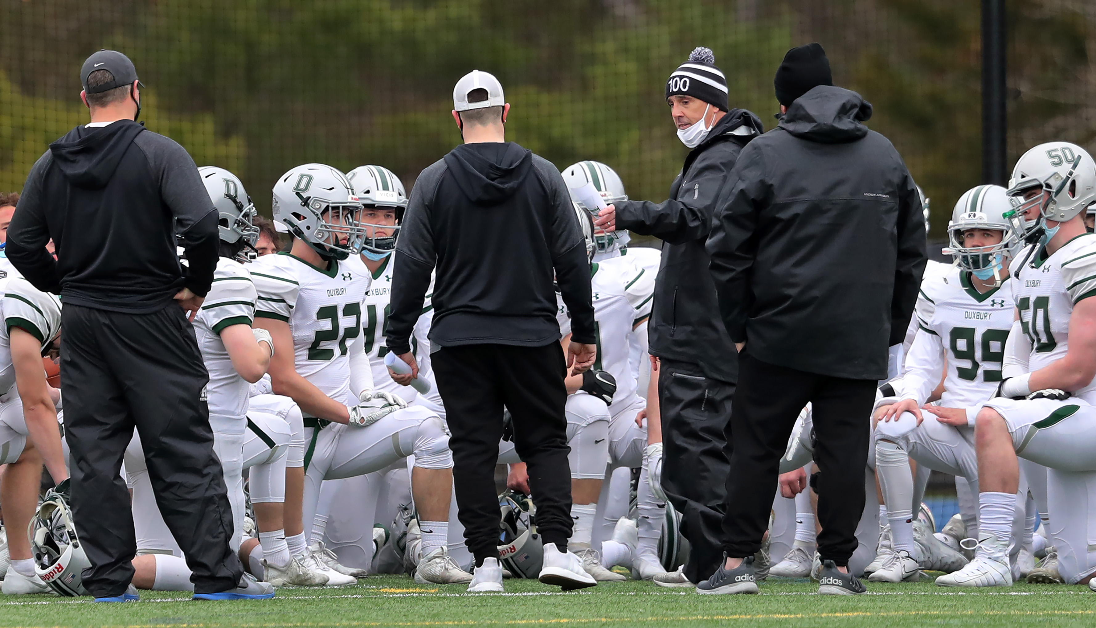 Duxbury coaches talked to the football team before the start of their game at Scituate on April 15, the team's first game since its season erupted in scandal and was paused on March 19.
