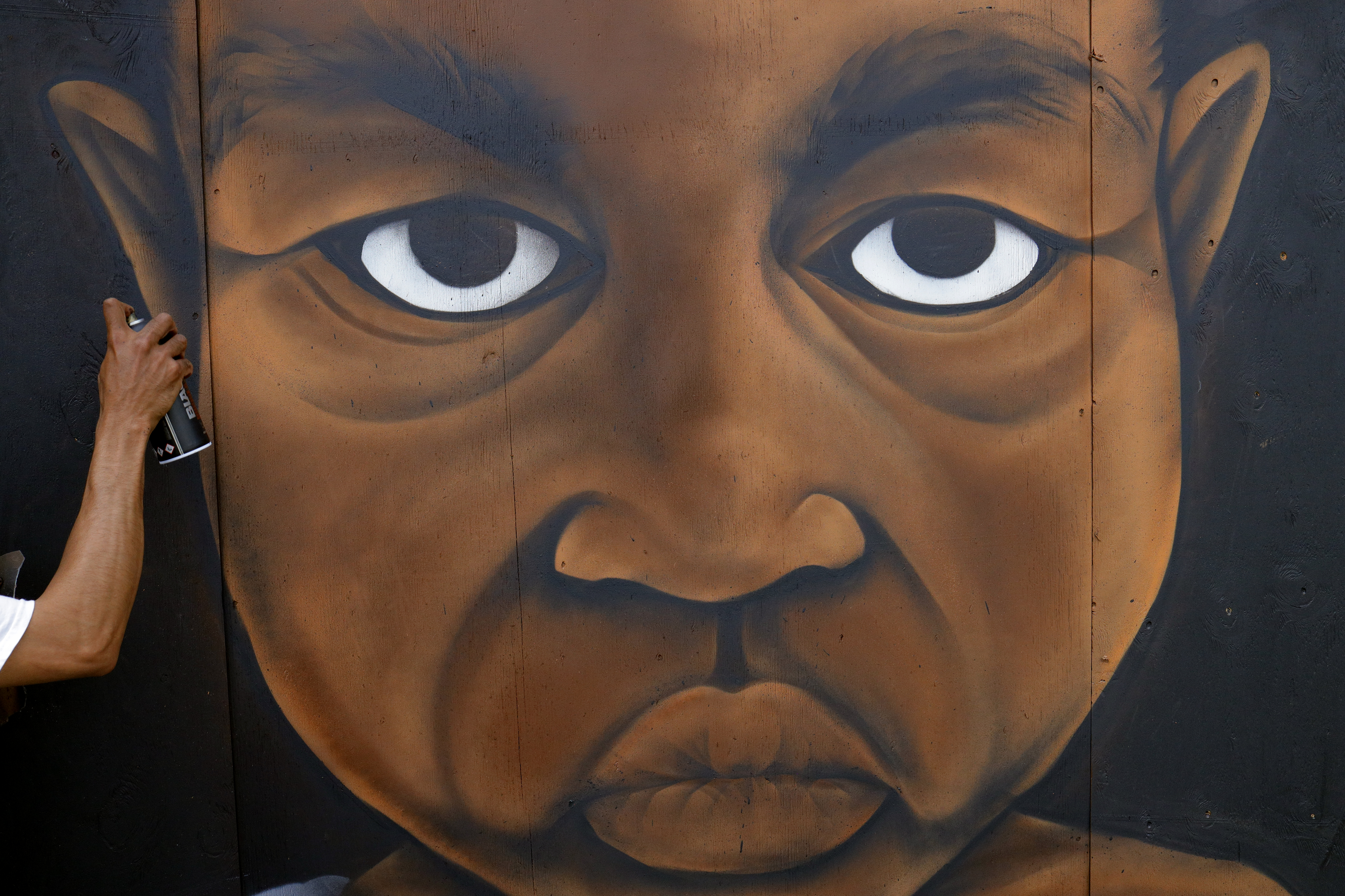 Artist Benny N. worked on a mural titled "Justice" on Westminster St. in Providence.