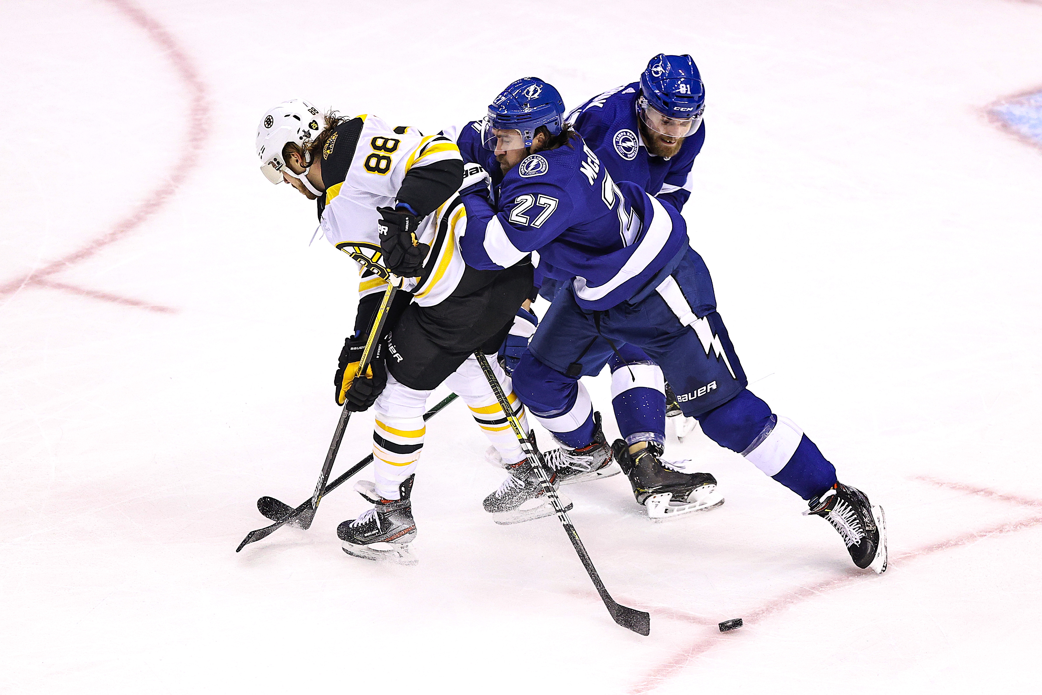 Tampa Bay's Ryan McDonagh checks David Pastrnak during the first period of Monday's action.