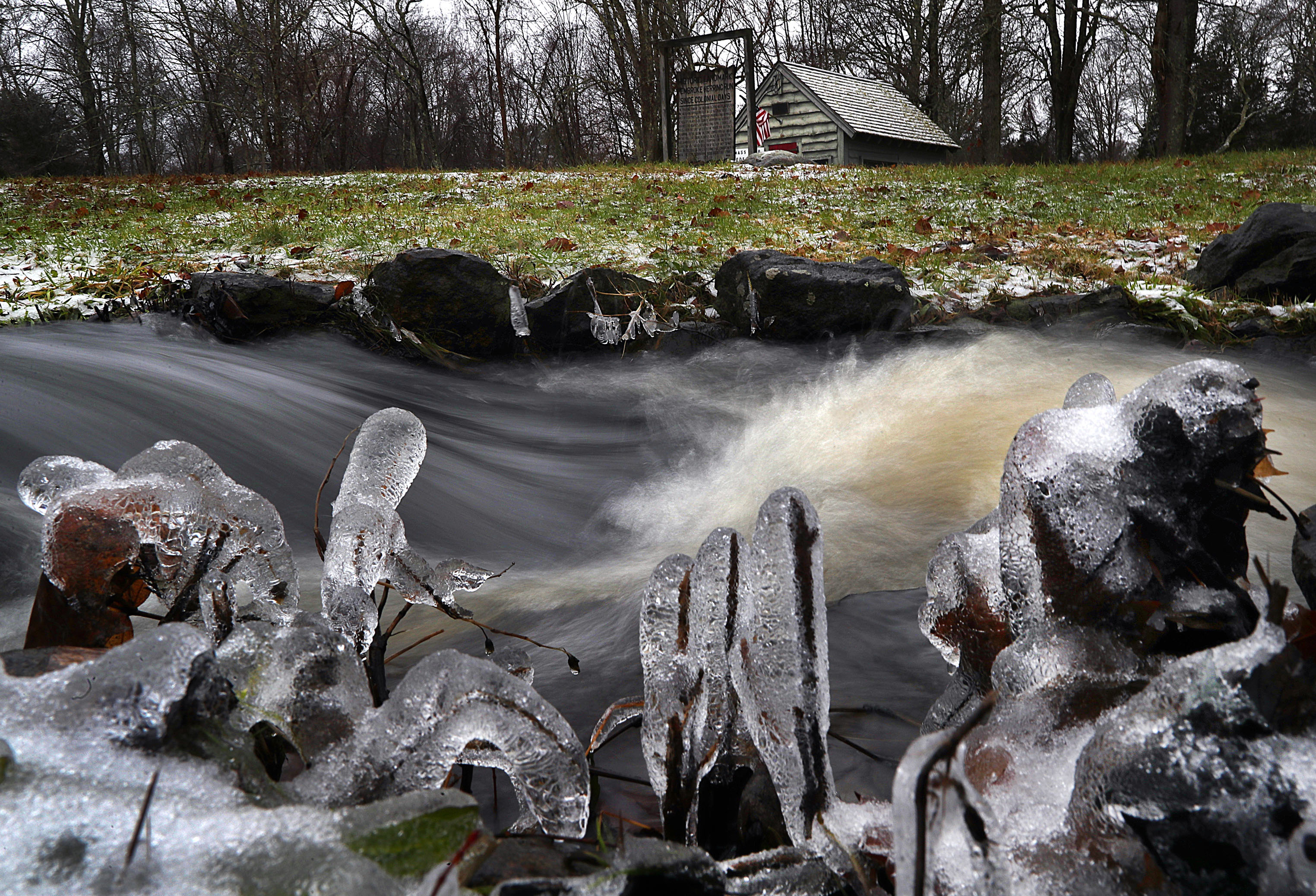 Ice clung to plants and rocks along the gushing Herring Brook in Pembroke after snow turned to ice and then rain during a storm on Dec. 17.