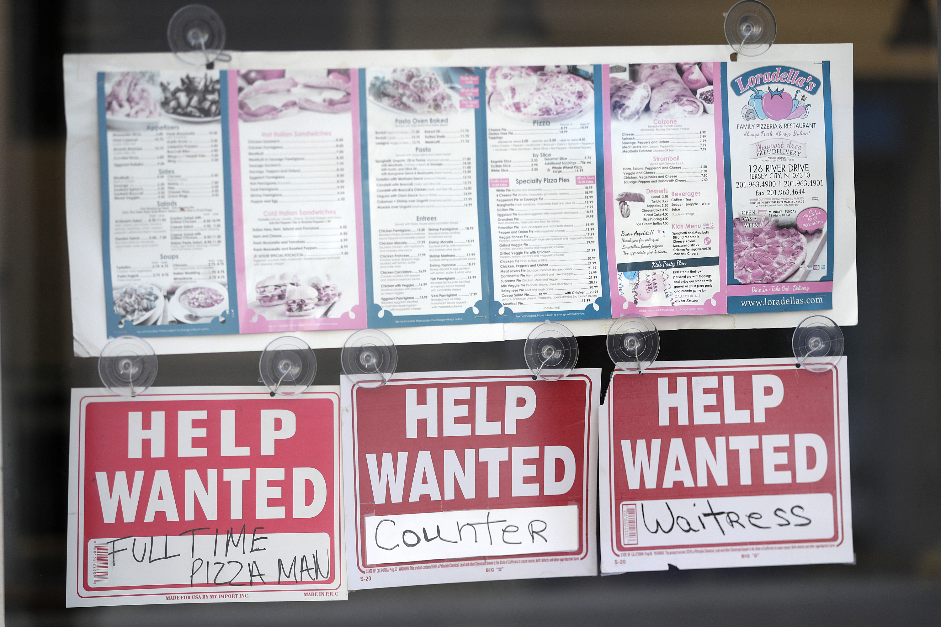 Help wanted signs hang below menus at a restaurant in the Newport section of Jersey City, N.J.,