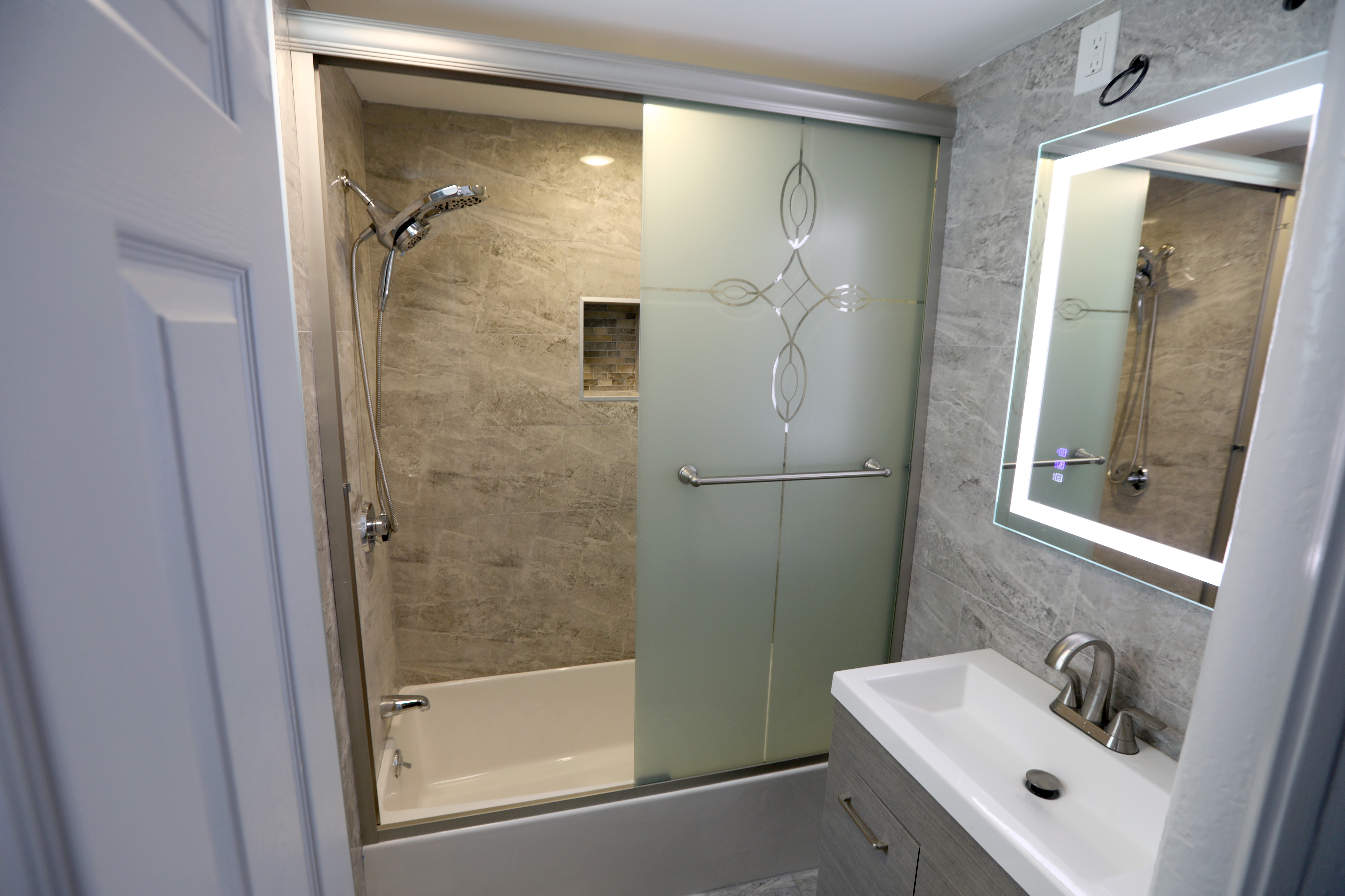 Wesley Williams Jr. converted his Mattapan basement into a one-bedroom apartment. The full bath has a high-tech mirror.