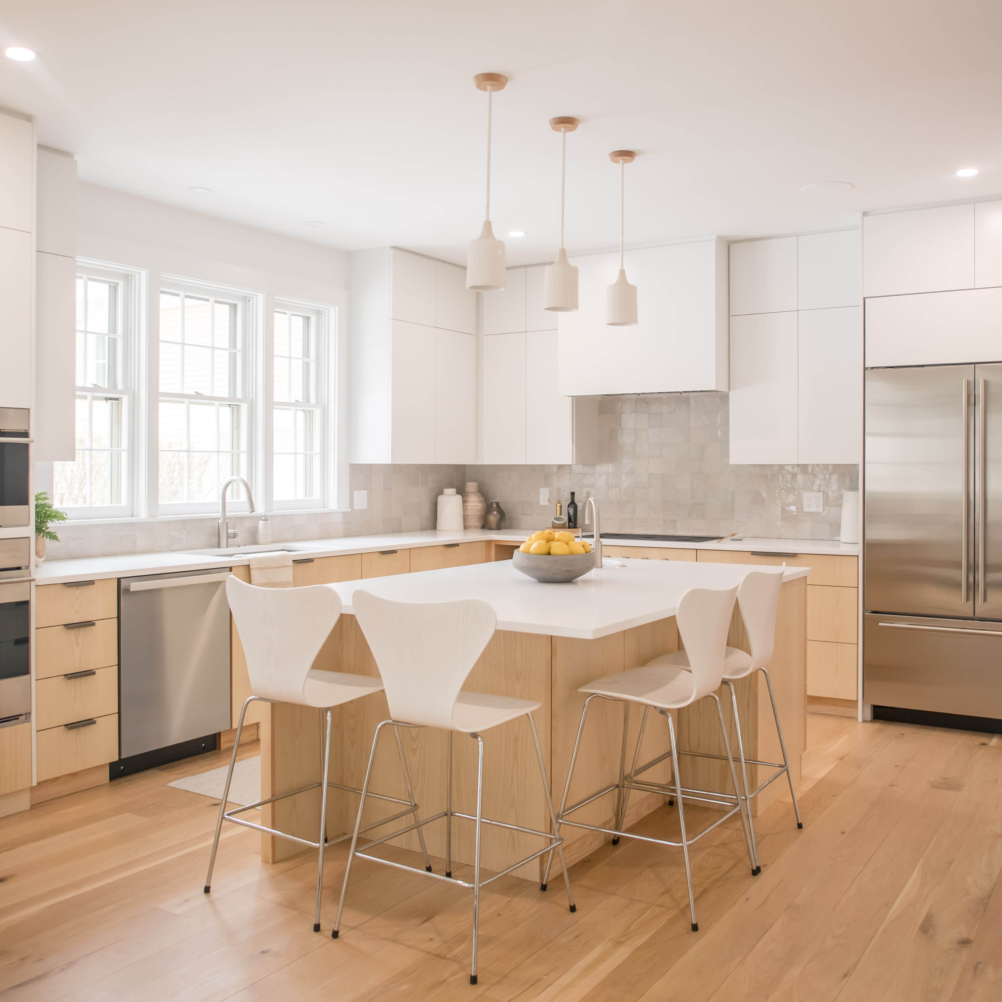 A local metalworker cut bar-height Arne Jacobsen stools to counter-height
for $15 apiece. The ridged
stoneware pendant lights in the kitchen are Cedar & Moss.