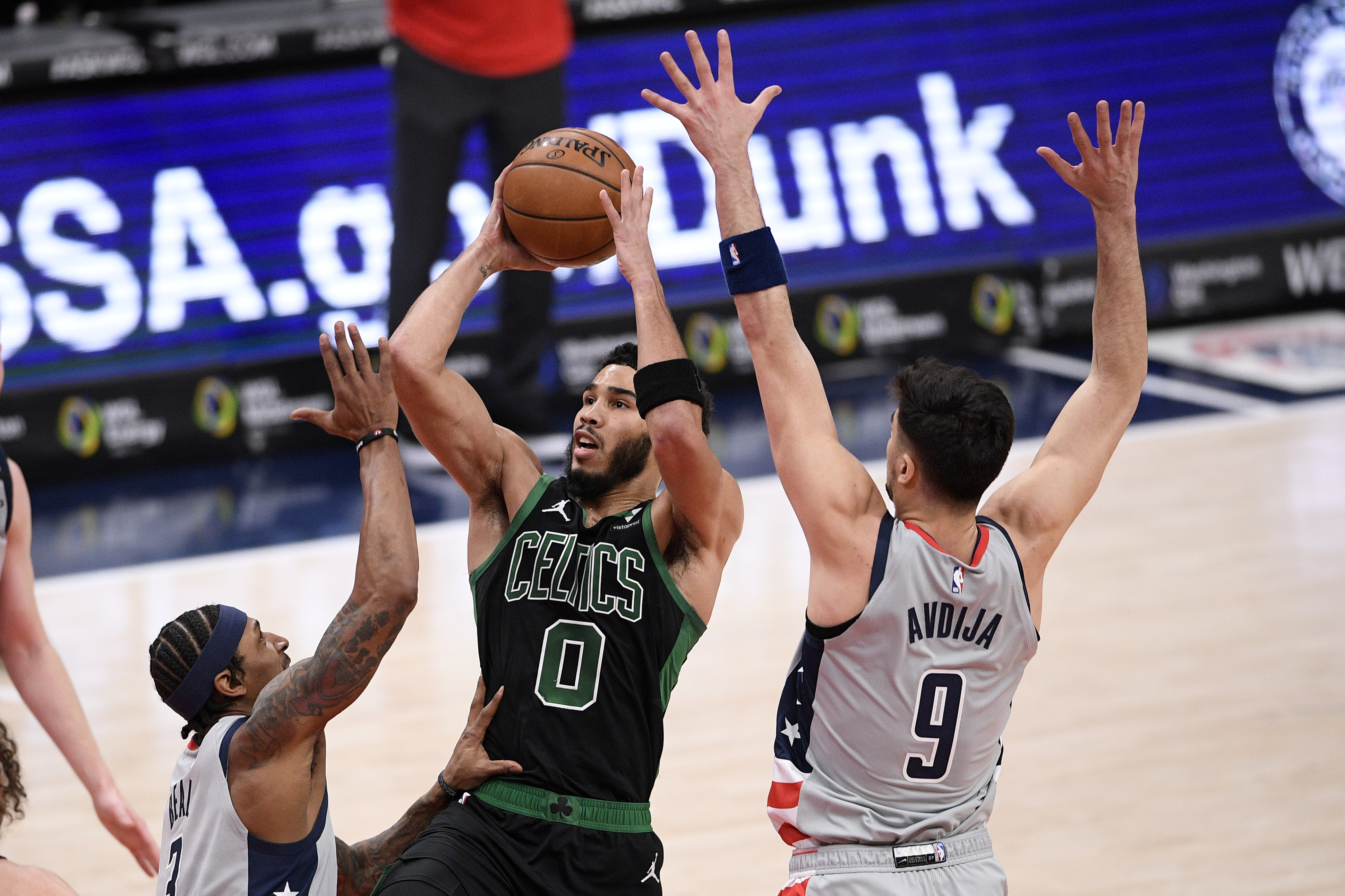 Jayson Tatum goes to the basket against Washington's Bradley Beal and forward Deni Avdija during the first half of Sunday's game.