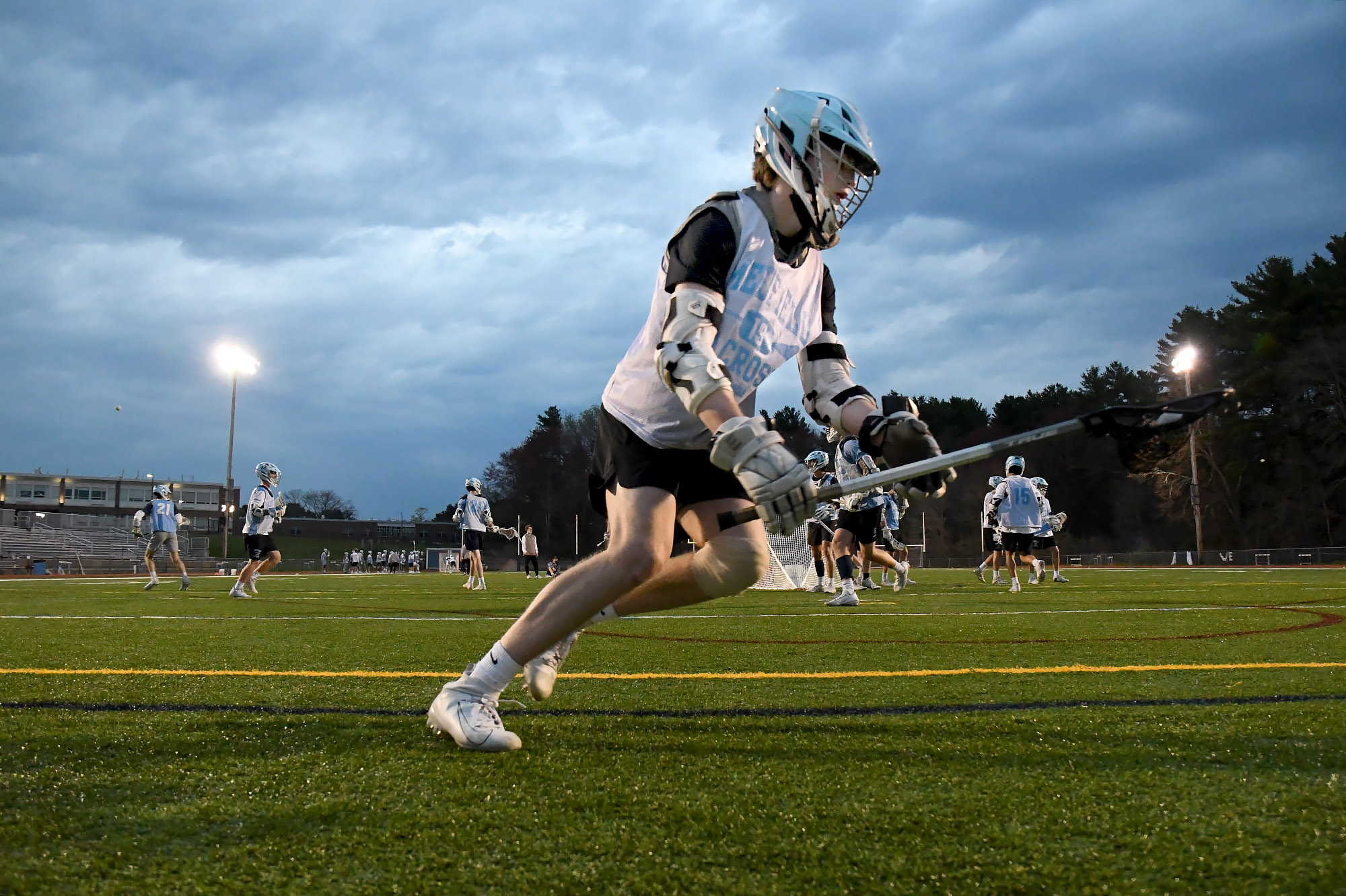 Medfield junior Cole Cloney scoops the ball from behind the net at Wednesday's practice.