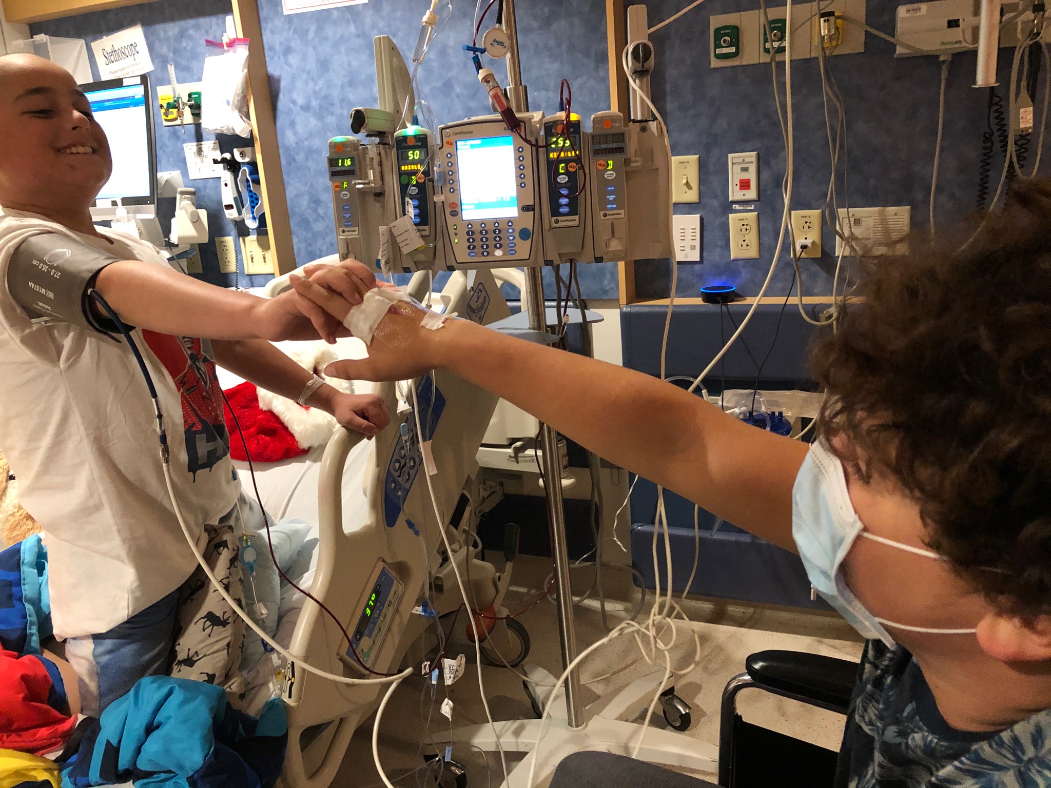 Still recovering from the procedure to have his stem cells extracted to donate to his brother, Leo (right) visited Mateo in his hospital room.