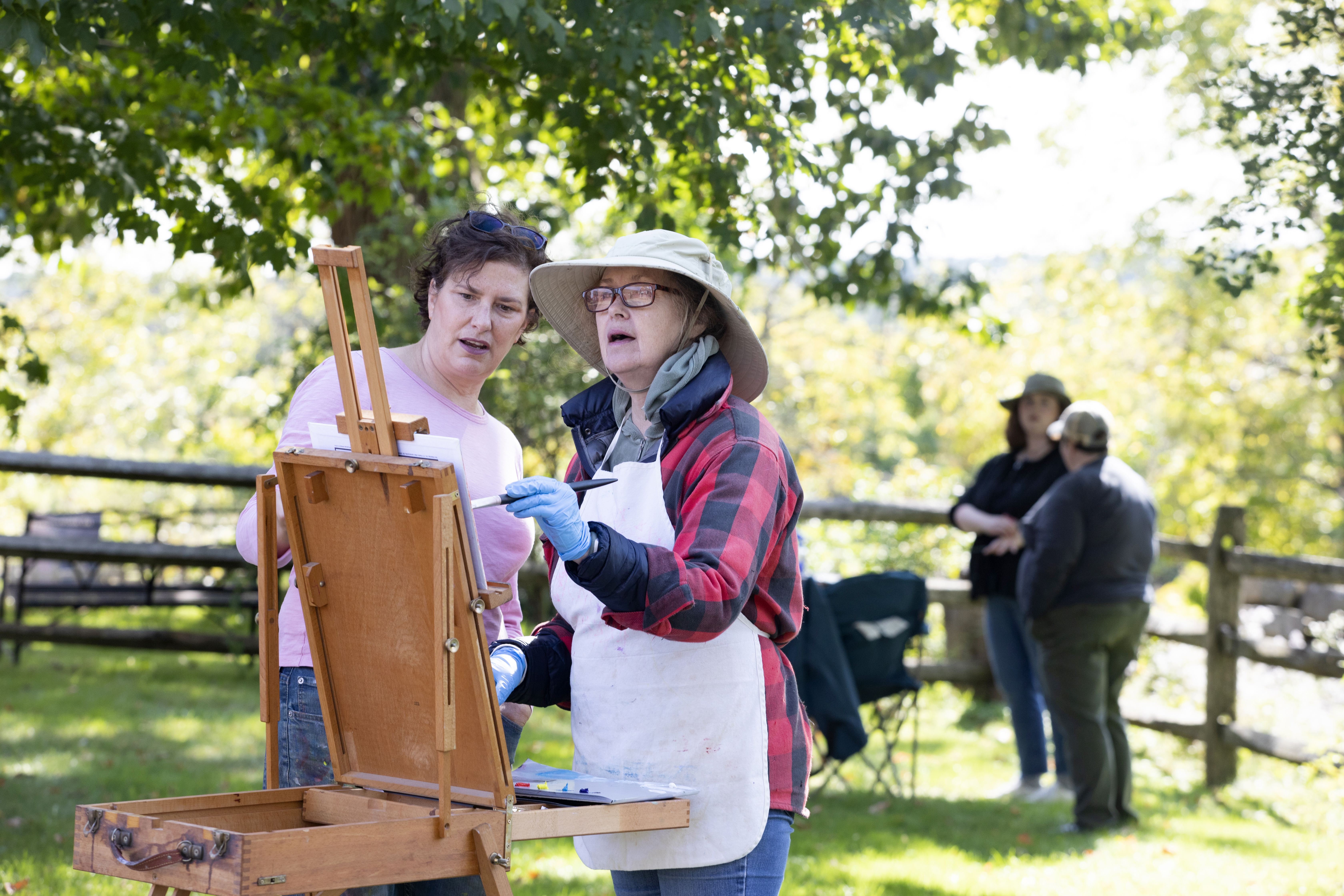 Art teacher Jessica Yurwitz, left, works with student Jane O'Maley of Rockport during an outdoor painting class at Cogswell's Grant in Essex. 