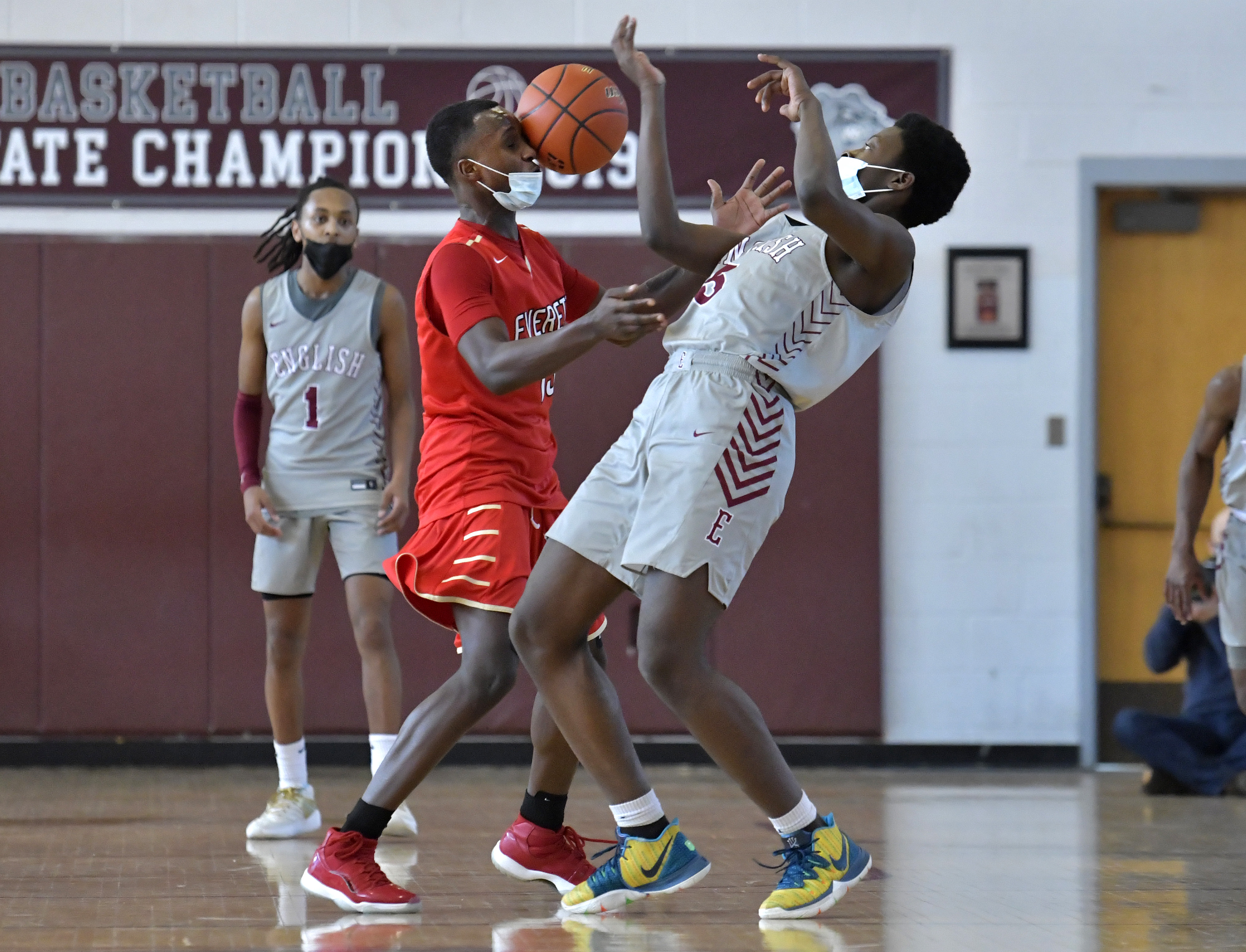 Juvens Louis (left) of Everett and Joshua St. Jean (5) of Lynn English battle for a loose ball during Saturday's Greater Boston League championship game.