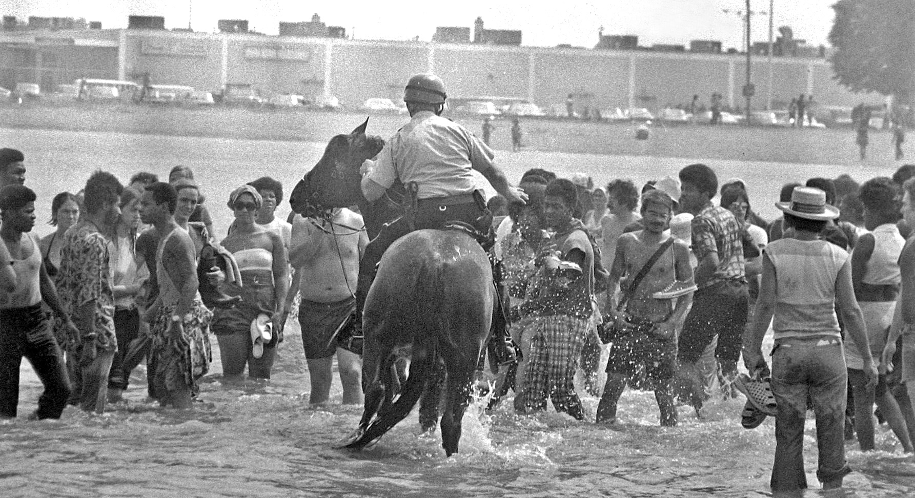 Police on horseback wade into the water at Carson Beach.