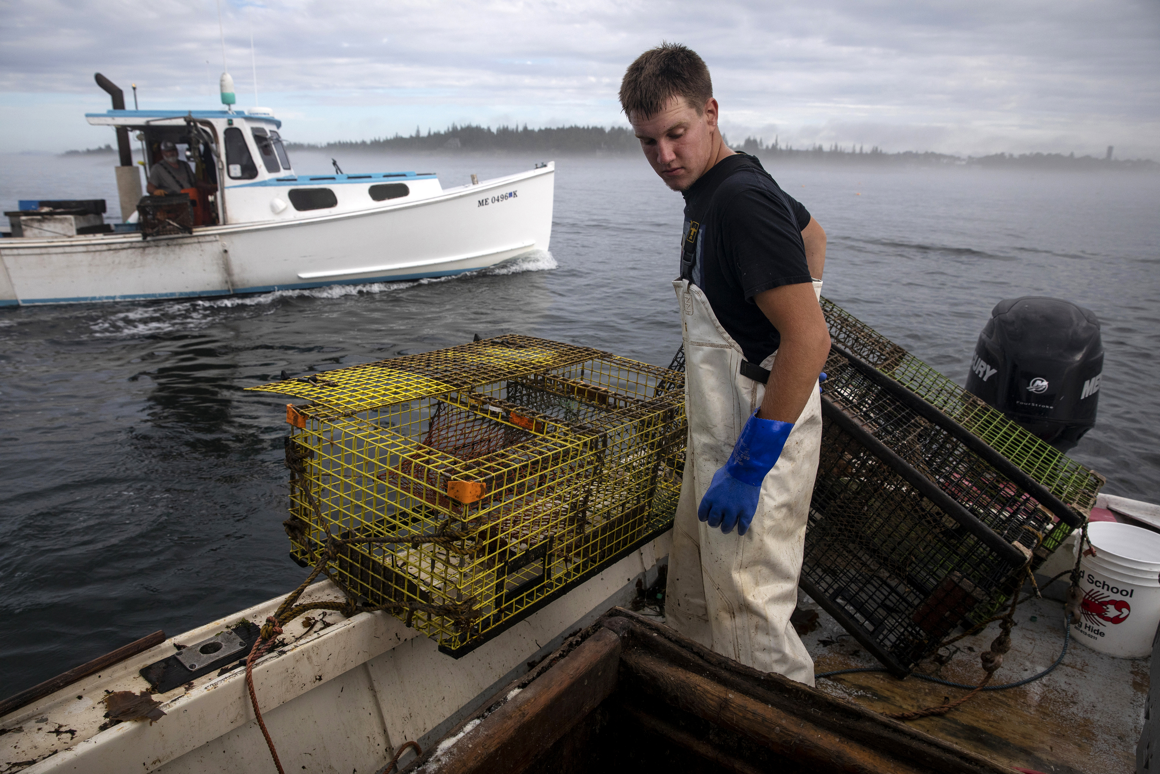 An older lobsterman passed by Tanner Lazaro as he hauled up his traps in his boat, Used N Abused, on Aug. 24. During the summer Tanner hauled his own traps on whatever days his mentor Frankie Thompson or another lobsterman didn't need his help.