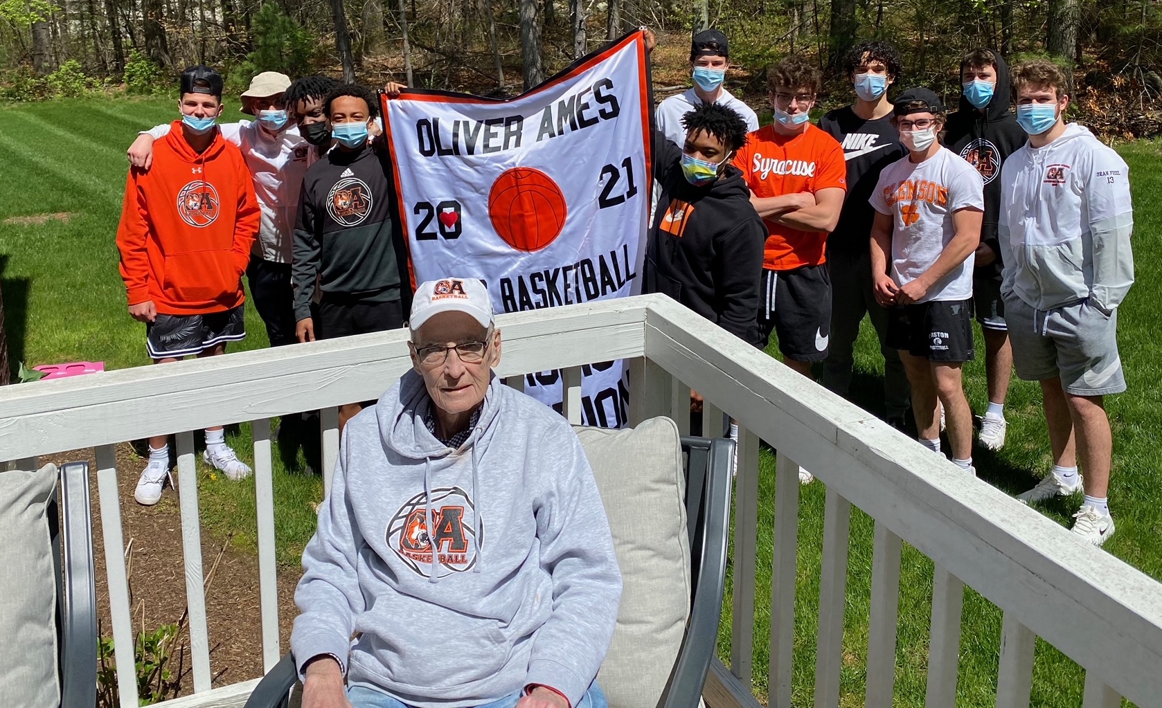 Oliver Ames players delivered the championship banner from their 2021 Hockomock League championship to the home of coach Don Byron (front), who was battling cancer.