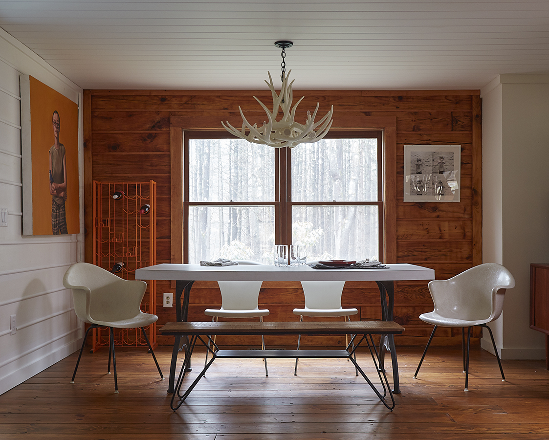In the dining room, nostalgia informed the laminate tabletop for the cast iron legs, which reminded Slingluff of a family beach house in Florida. The homeowners purchased the orange
painting from David Young when he and Katherine had a portrait show together.