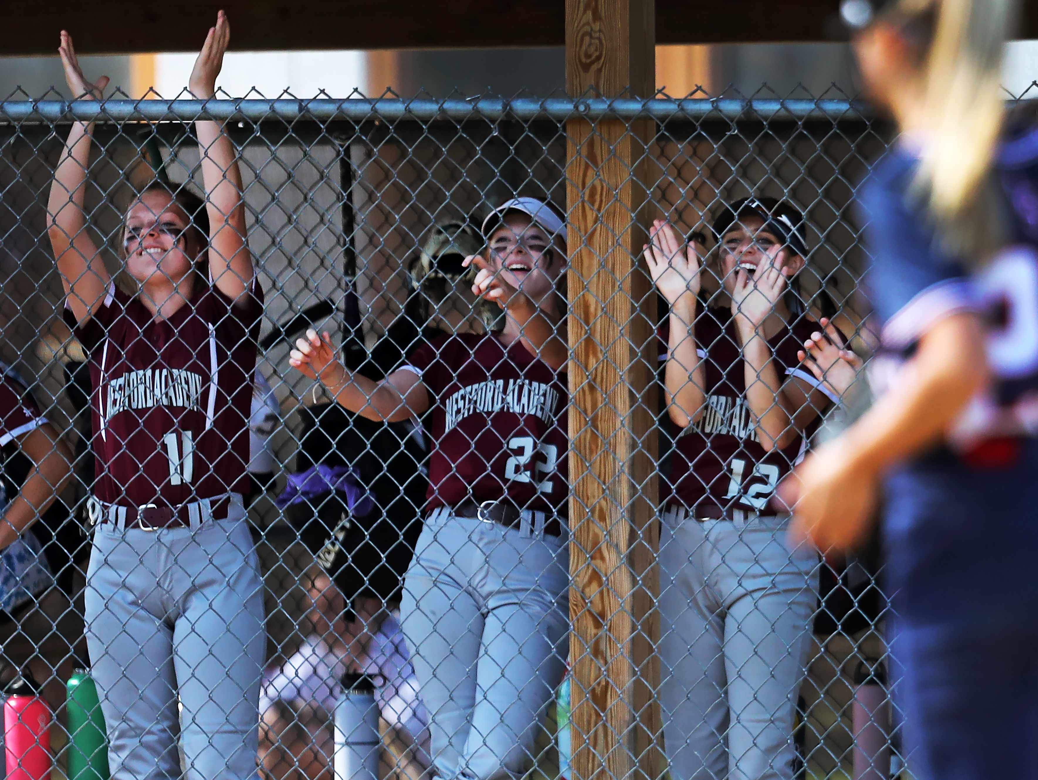 From left, Westford Academy's Kate Dulczewski (11), Anabelle Arnolds (22) and Madelyn Haley (12) react in the dugout after the Grey Ghosts scored a run against Lincoln-Sudbury.