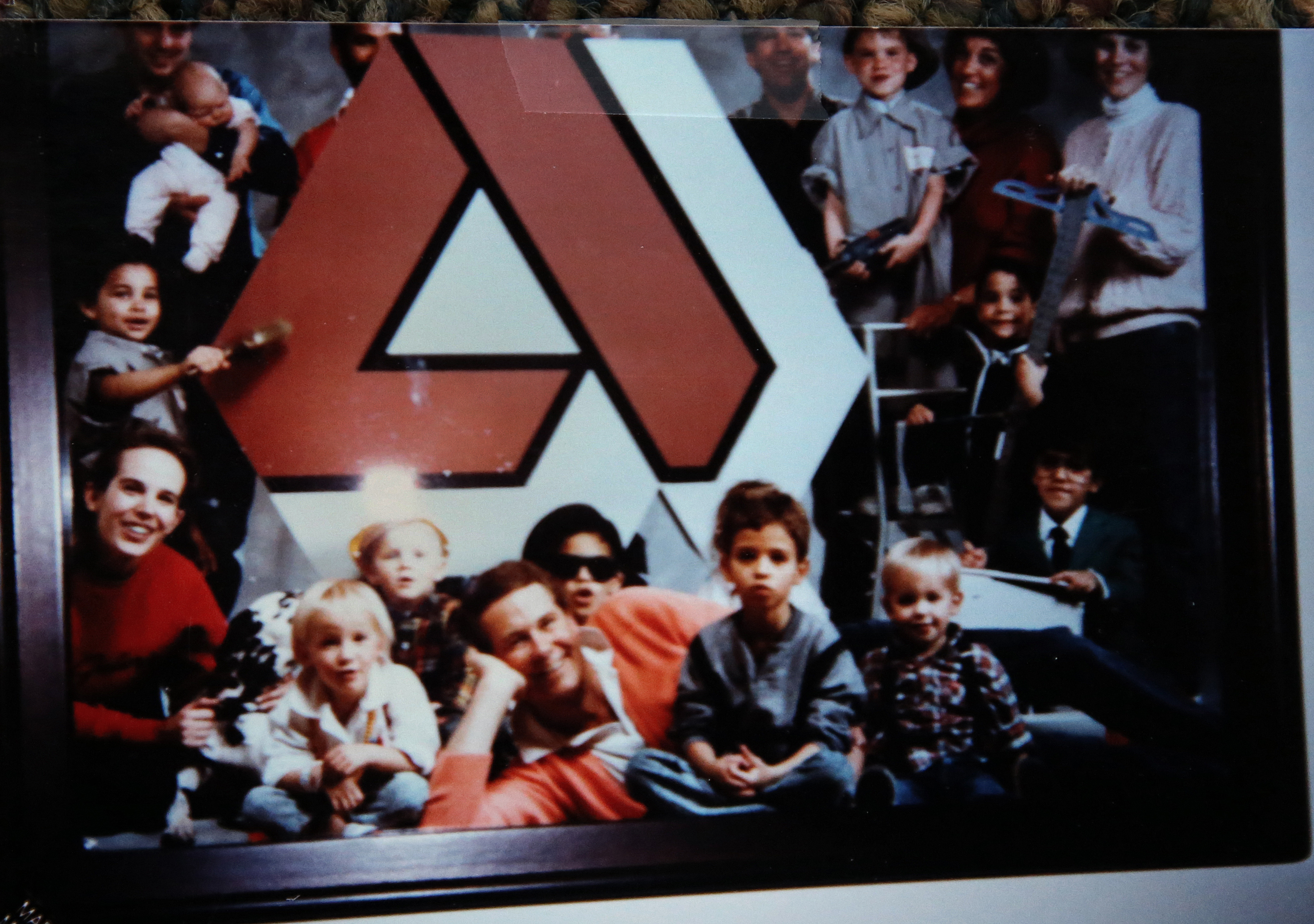 A photo of Amy as a child (front row, left) next to her father with other children of parents employed at company.