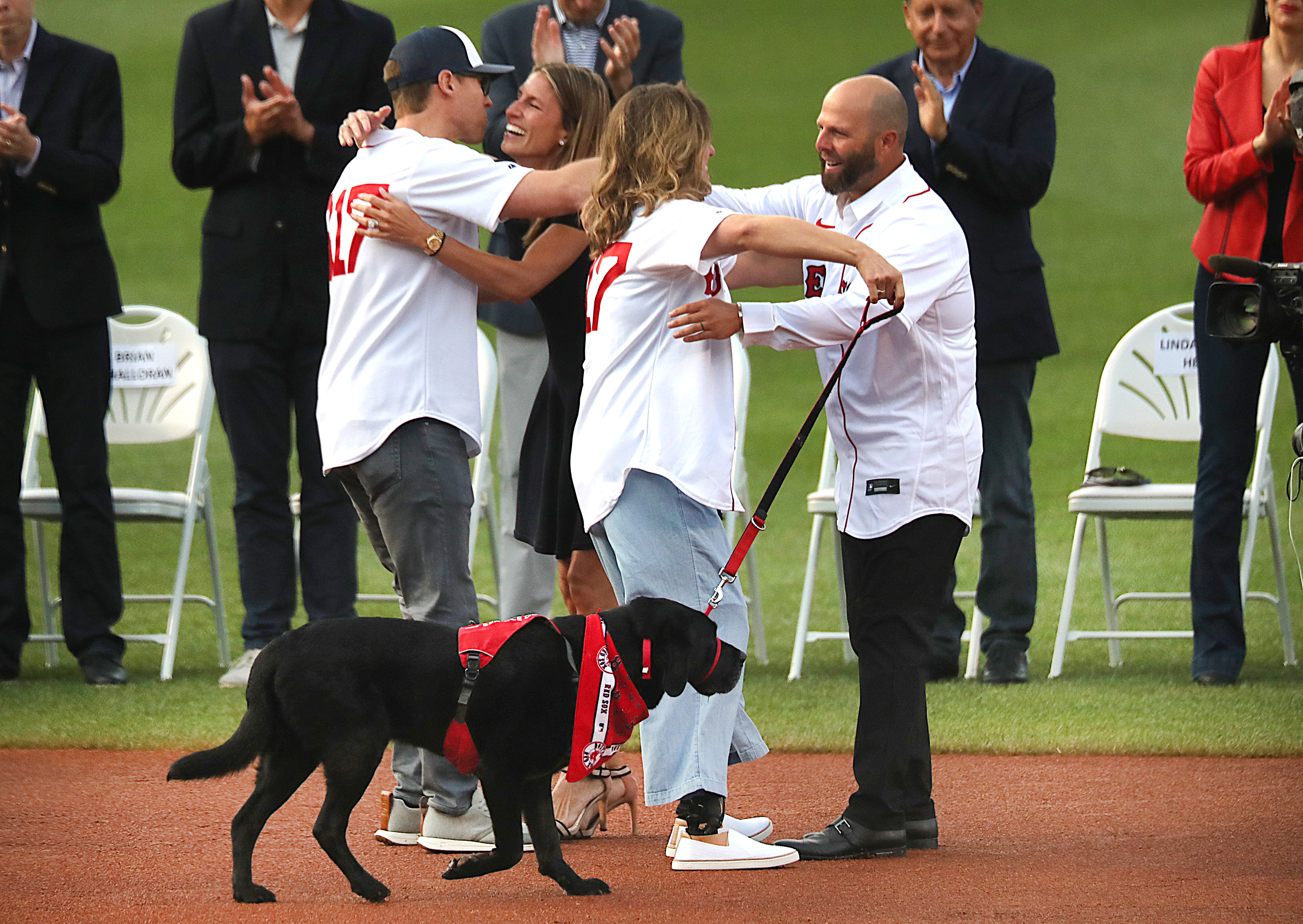 Former Boston Red Sox's Dustin Pedroia, right, walks off the field with his  family and former player Pedro Martinez, left, after ceremonies in  Pedroia's honor before a baseball game against the New