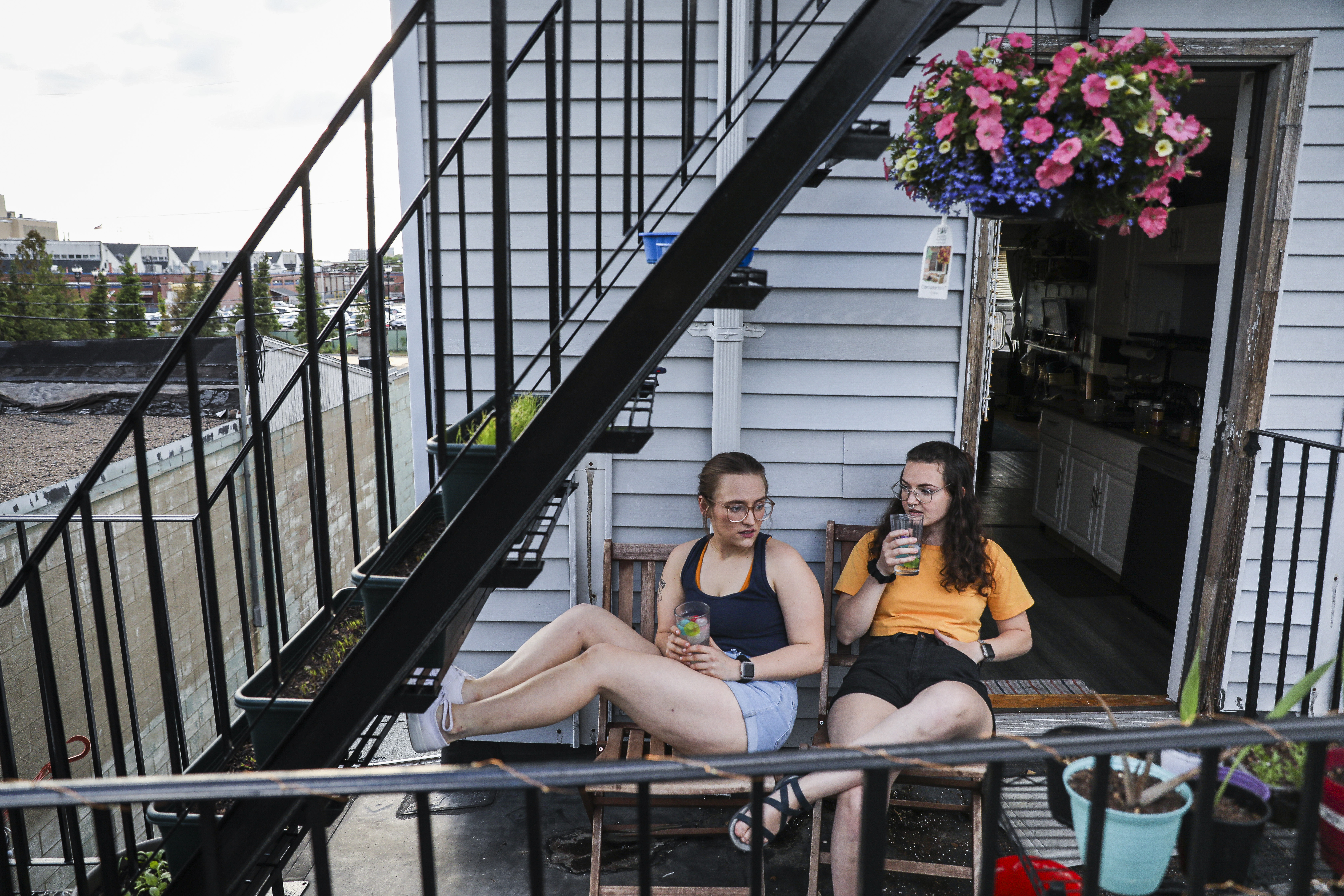 Sarah Hehrer (right) talked with her roommate Margaret Born on the fire escape of their Everett apartment.