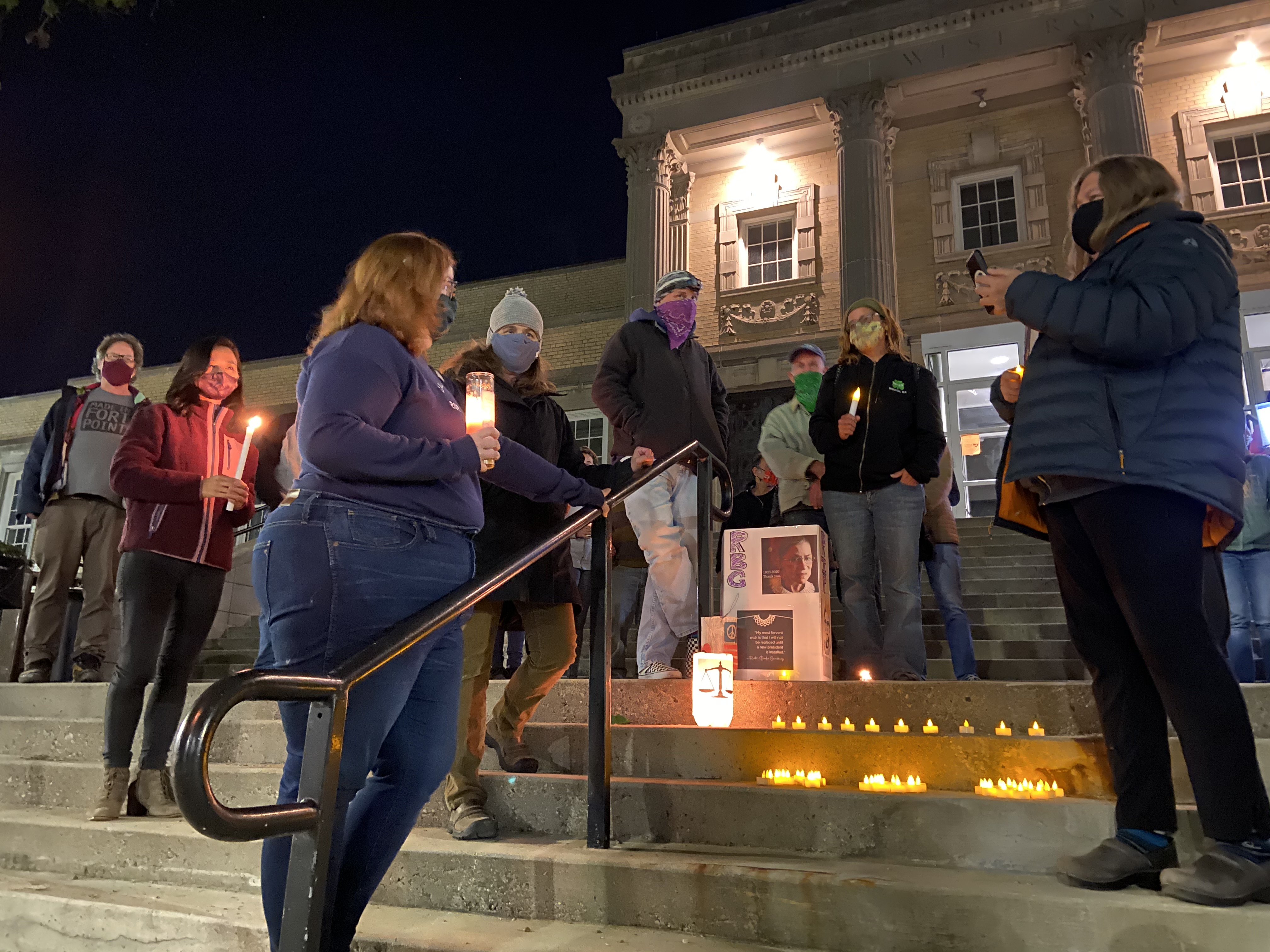 Grieving community members paid tribute to the late Supreme Court Justice Ruth Bader Ginsburg outside the West Roxbury division of the Boston Municipal Court on Saturday night.