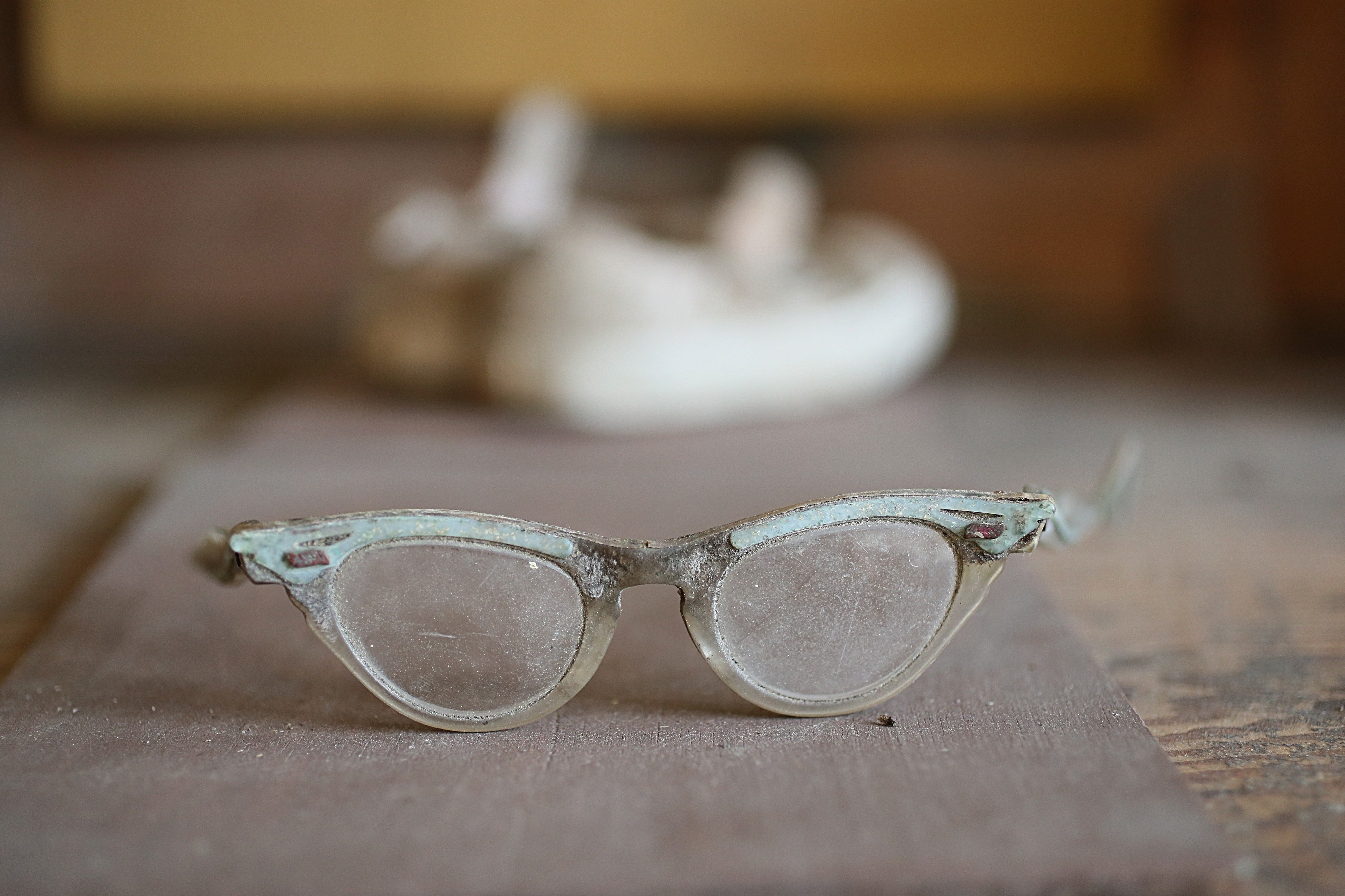 A pair of faded green glasses and baby shoes at the Museum of Everyday Life.