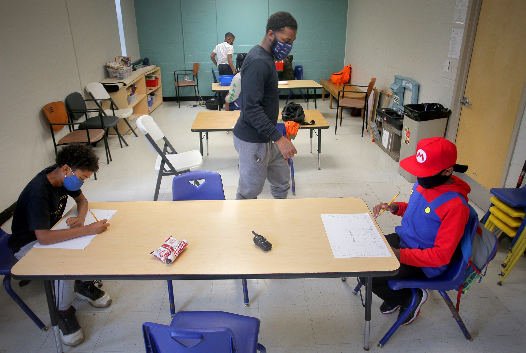Dorchester YMCA Assistant Director Darius Rutledge made his way around the room helping kids with their drawings.