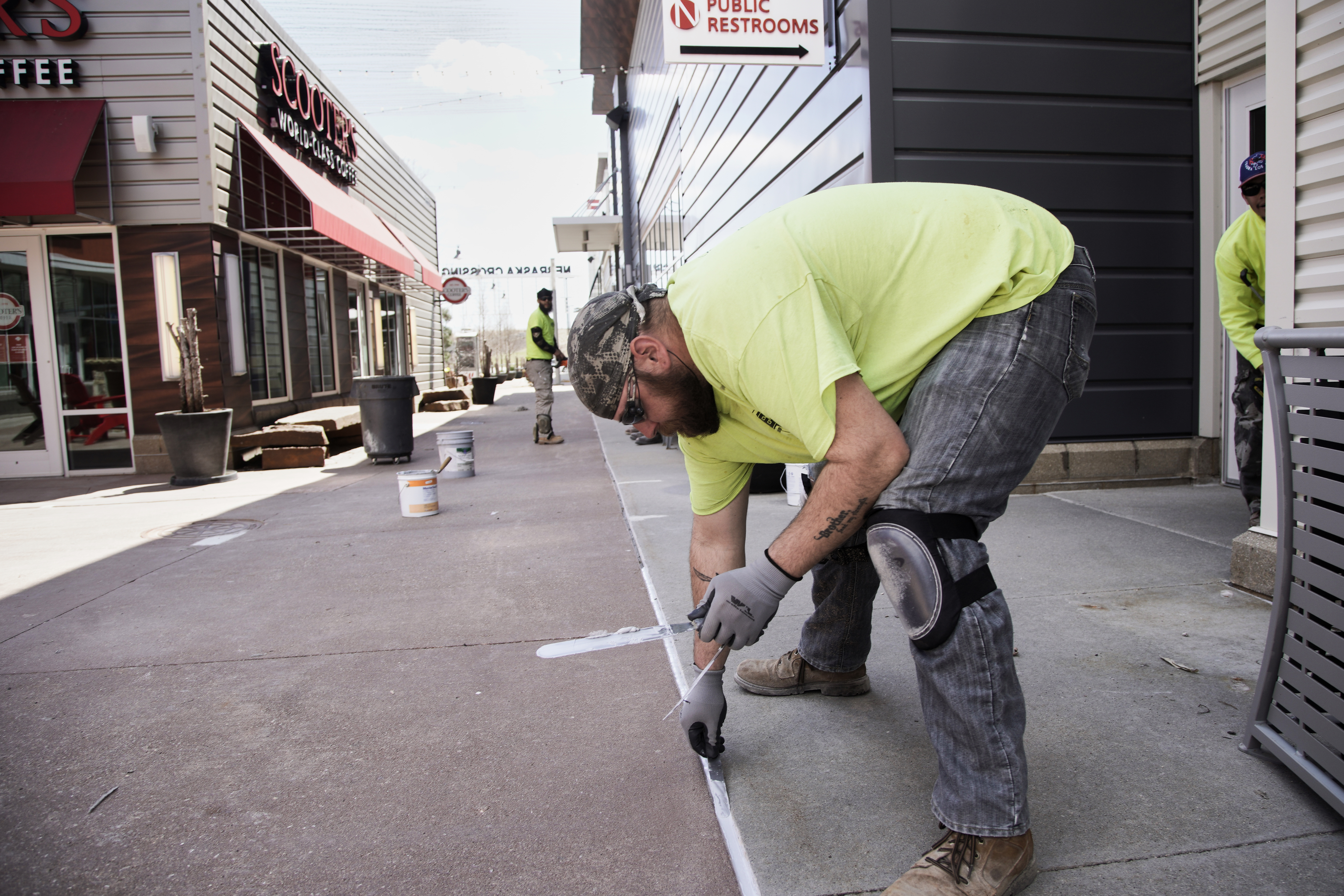 Maintenance workers touch up a sidewalk at the Nebraska Crossing Outlets outdoor mall near Gretna on April 20.