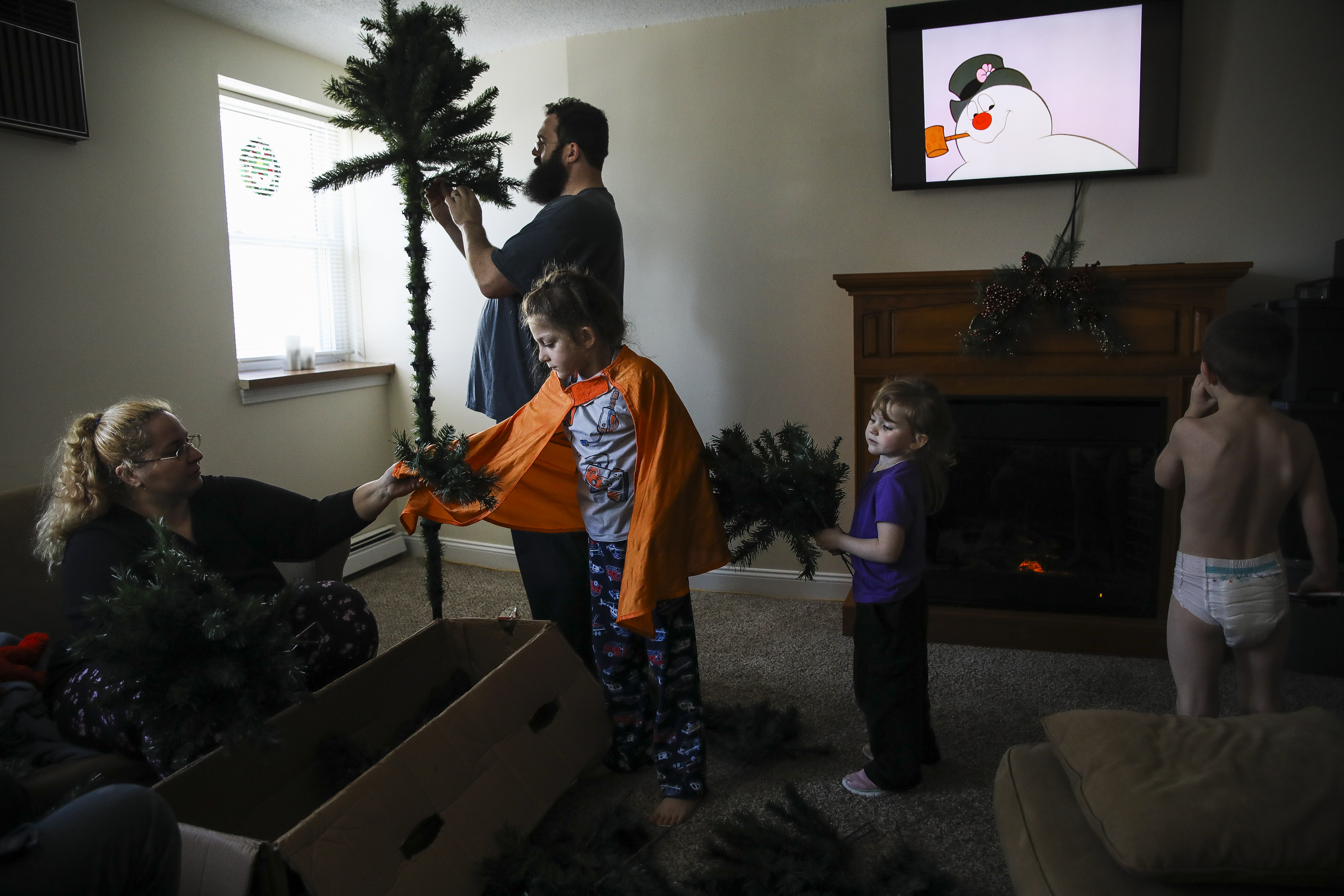 Frosty the Snowman plays in the background while Mariah hands a branch to her son Evan as they set up their Christmas tree in the living room. With boxes still left to unpack, the Lupien family is slowly settling into their new apartment. “Between the better paying job and learning how to manage what we have, has left us with a new and quite strange feeling of not needing to panic,” said Mariah. “The sadness and shame from not being able to provide as well as we have wanted to, that well worn path in my brain, all that energy can be rerouted to somewhere else.”